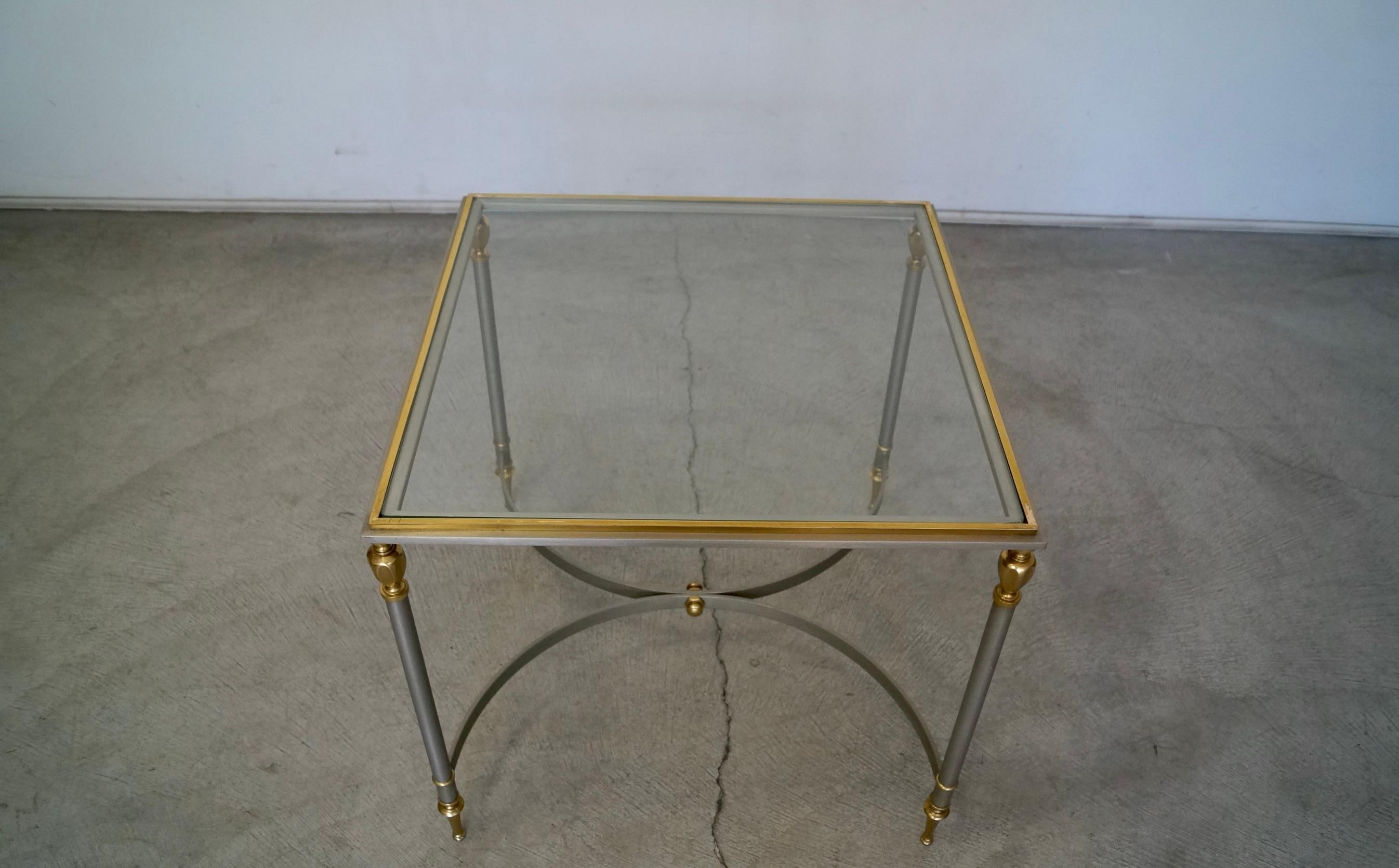 Vintage Hollywood Regency cocktail table / side table for sale. From the late 1960s, and manufactured in Italy. It's really well designed and well constructed, and made of solid materials. It has a solid stainless steel frame with brass feet, brass