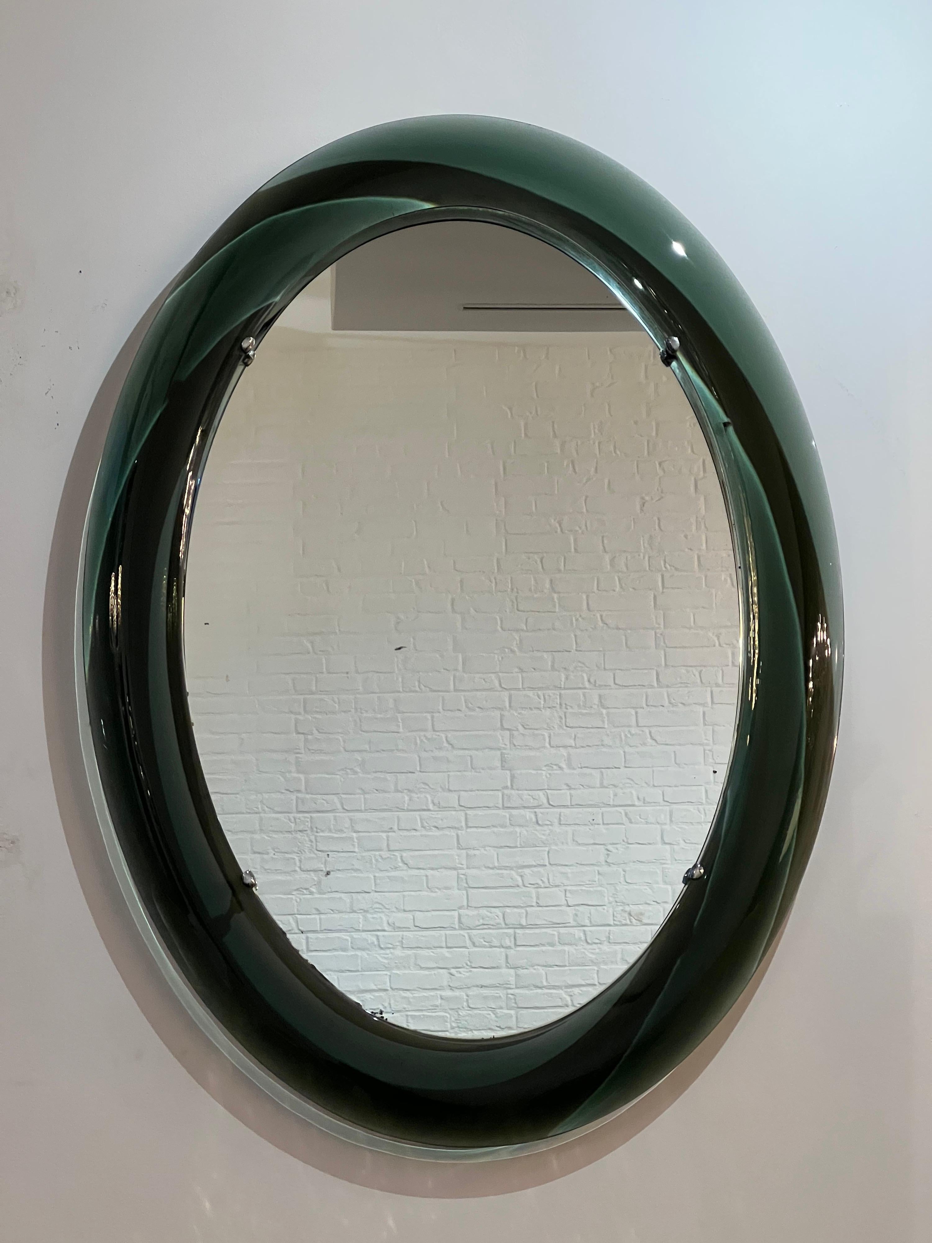 A beautiful large 1960s Italian oval mirror framed in a sea green glass surround with chrome details. 

Dimensions: H:94cm W:69cm D:4cm