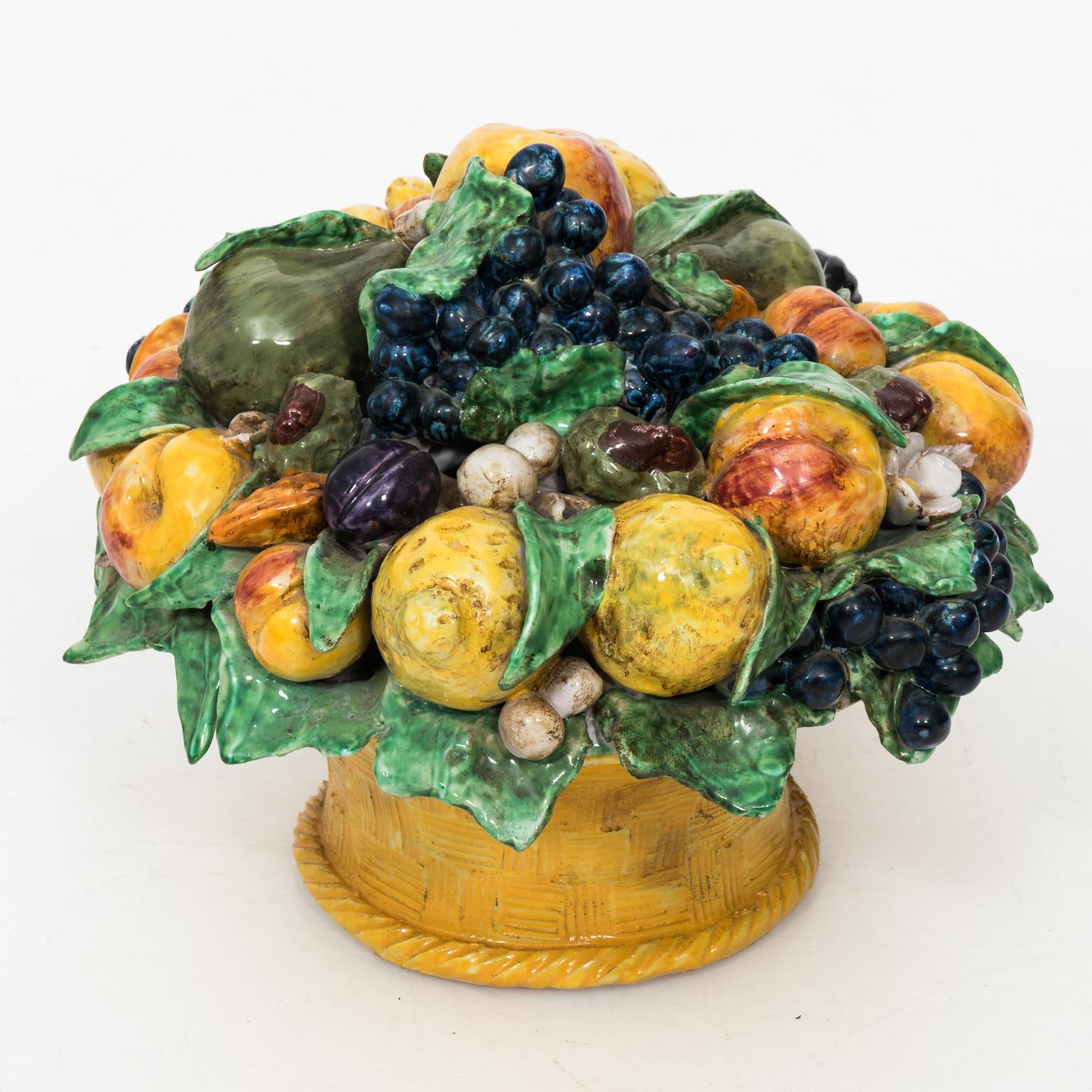 Oversized vintage Italian majolica ceramic fruit basket, with life size lemons, apples, grapes, leaves, flowers, pears and apples. Signed and hand painted in glazed finish. There are some chips throughout the piece.
 