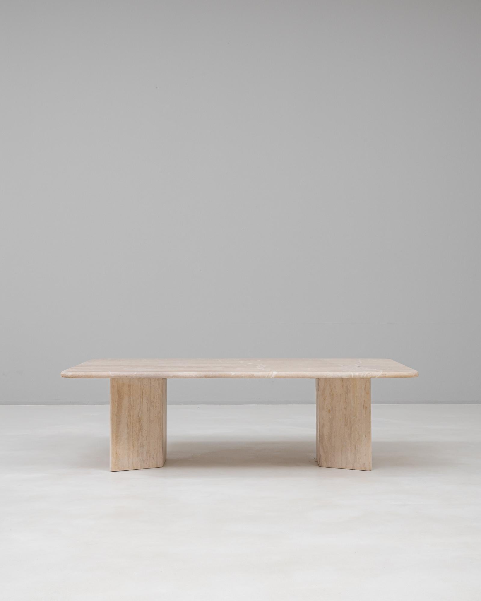 This 1960s Italian marble coffee table exemplifies the minimalist elegance and timeless sophistication of mid-century design. Crafted from richly veined marble in soft neutral tones, the table features a rectangular top with subtly rounded edges,