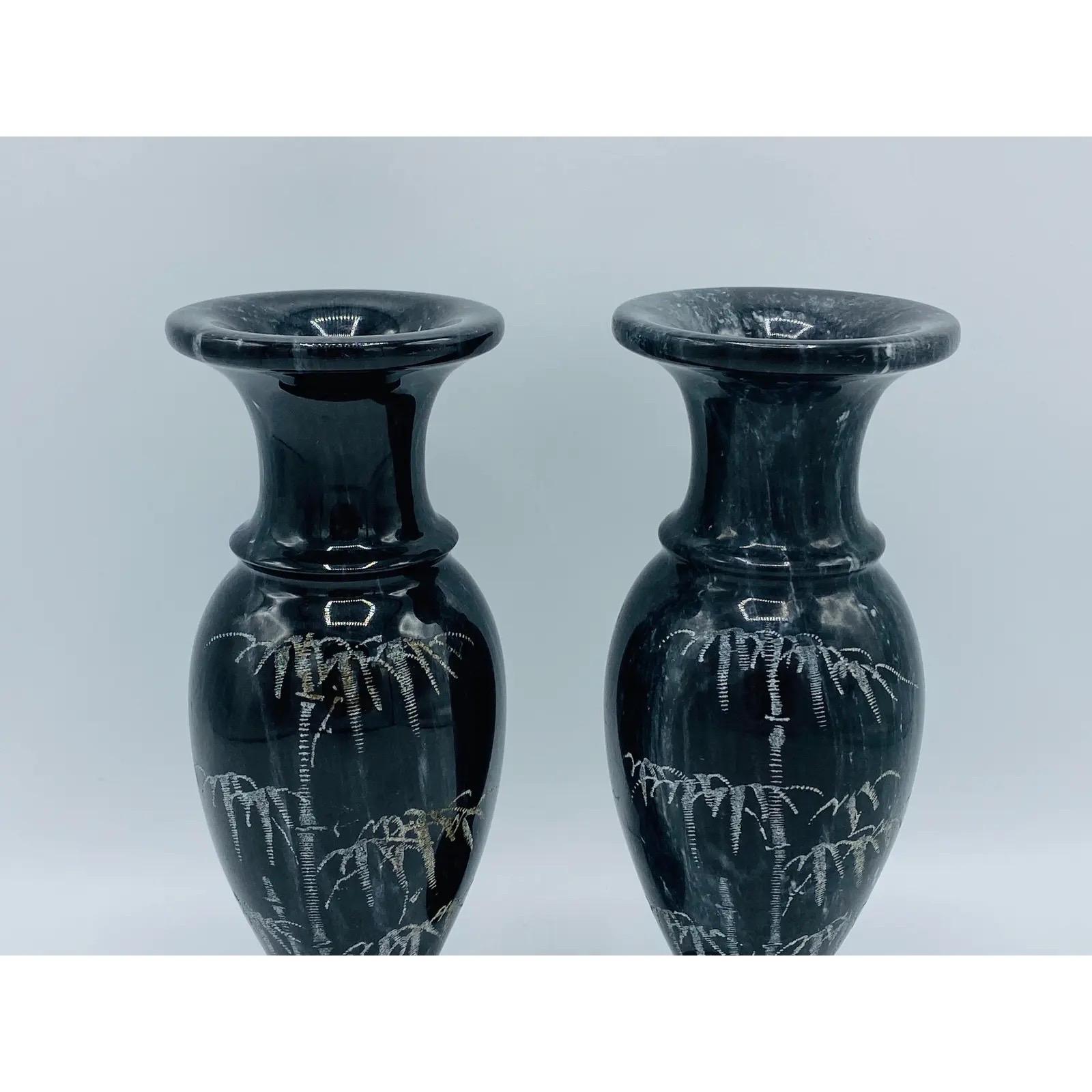Listed is a stunning, pair of 1960's Italian marble vases. The pair are primarily black with white veining and a bamboo motif etched along one side of each. Heavy, weighing 4.7lbs/pair.