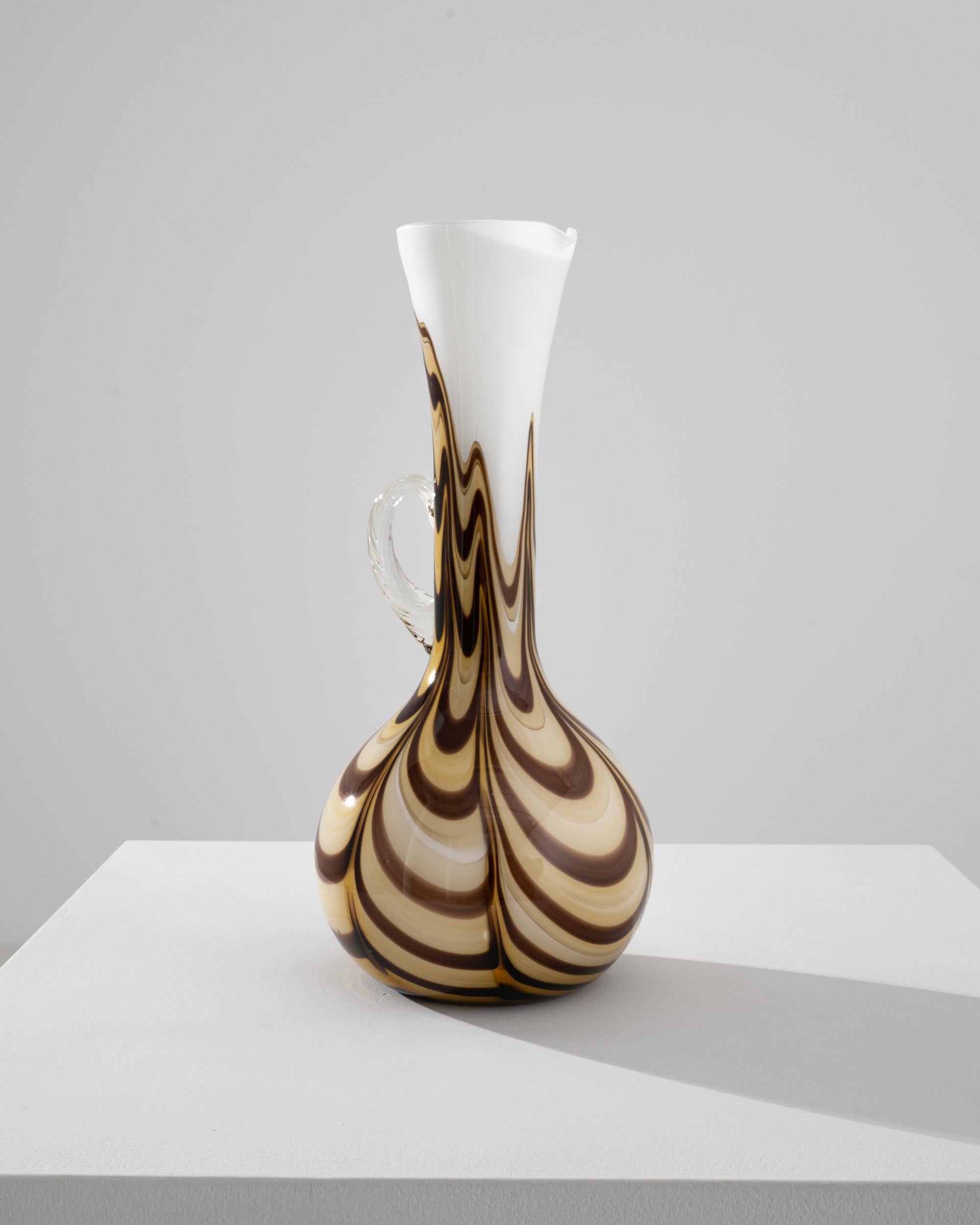 Romantic and striking, this glass vase offers a unique vintage accent. Made in Italy in the 1960s, the shape is elegant and piercing: a slender handle gracefully merges with the colored glass vessel. Beautifully crafted, the semi-translucent glass