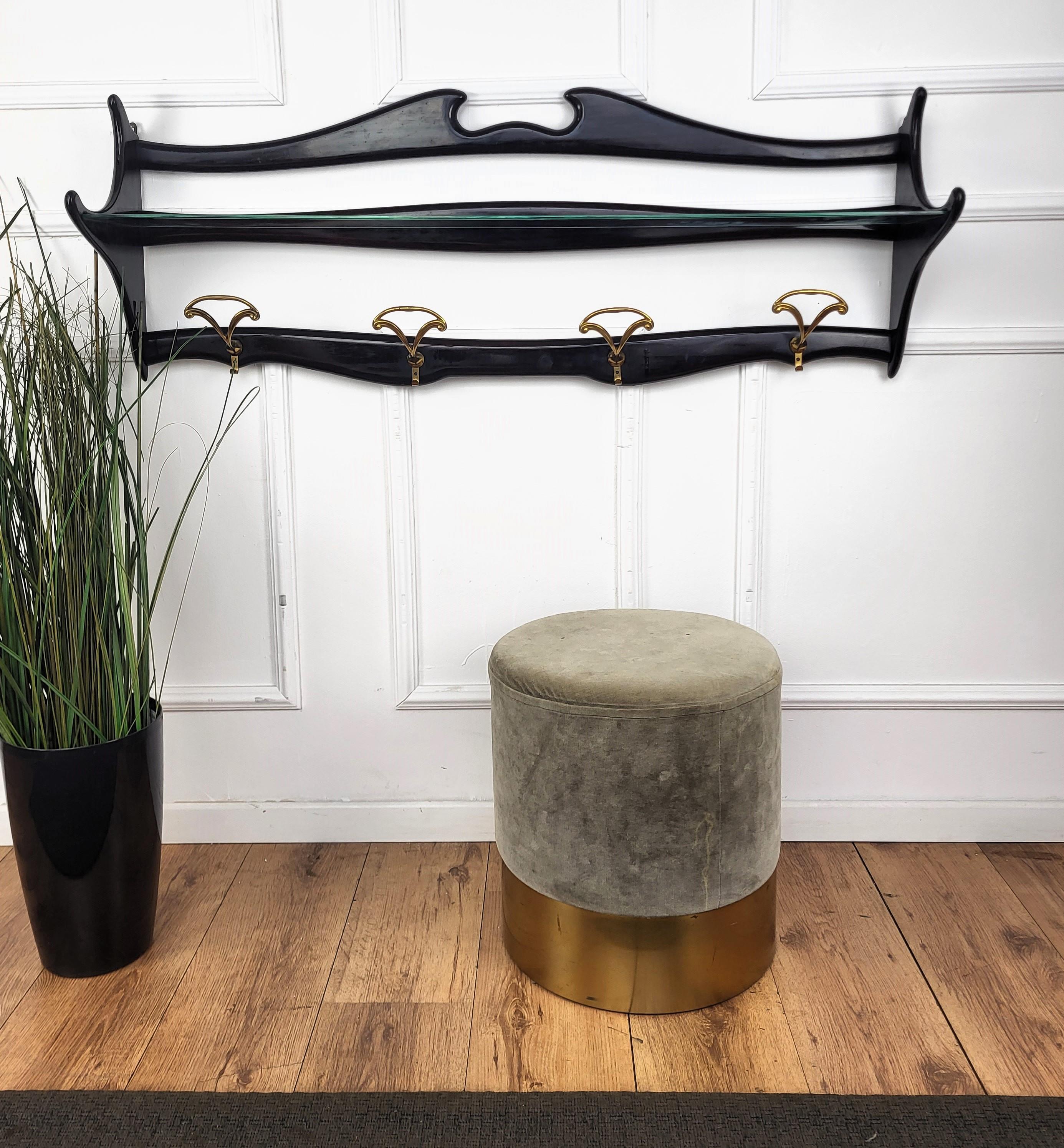 Beautiful 1960s Italian Chiavari style wall coat hanger in carved wood with great shiny black lacquer vintage patina solid structure with glass shelf and brass hangers. The shapely crest is typical of Chiavari style, mainly known for the chairs,