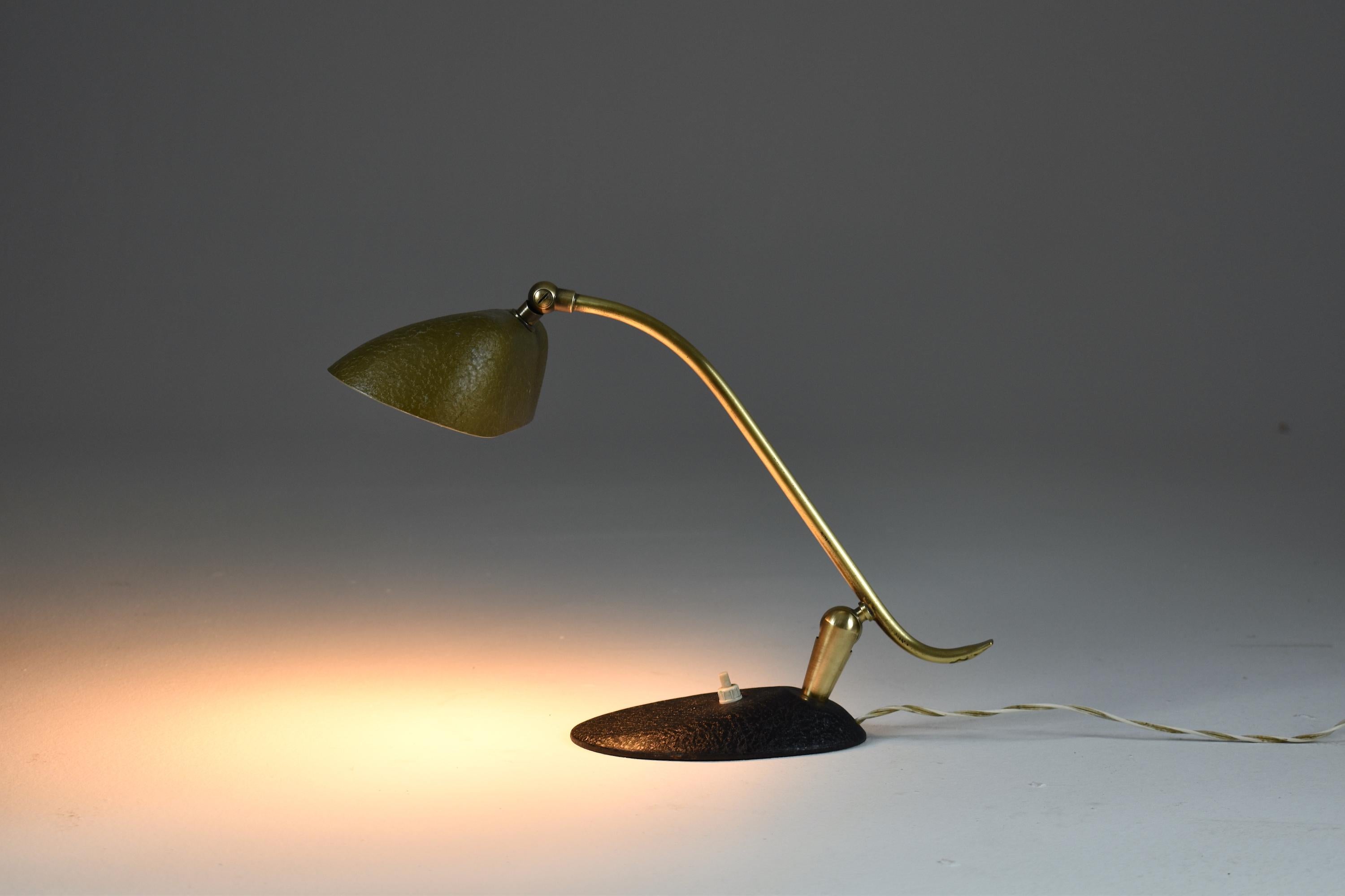 A beautiful 20th-century vintage table or desk lamp composed of an aluminum shade, a black lacquered steel base, and a slender brass stem. This light rotates at the shade and stem and is designed with a push-type light switch on the base.