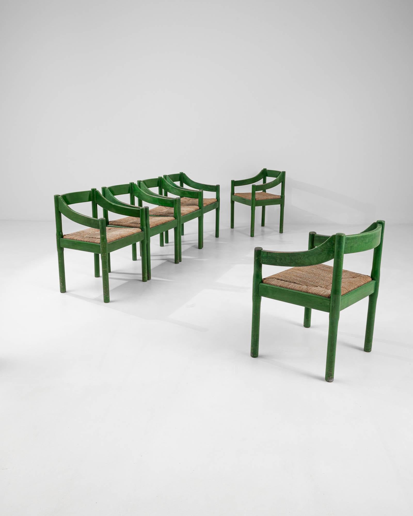Made in Italy circa 1960, these wooden armchairs are made with a woven rush seat. The bright green finish gives these minimal chairs a striking visual twist, enlivening the otherwise subdued design with a vibrant presence. Manufactured by Cassina,