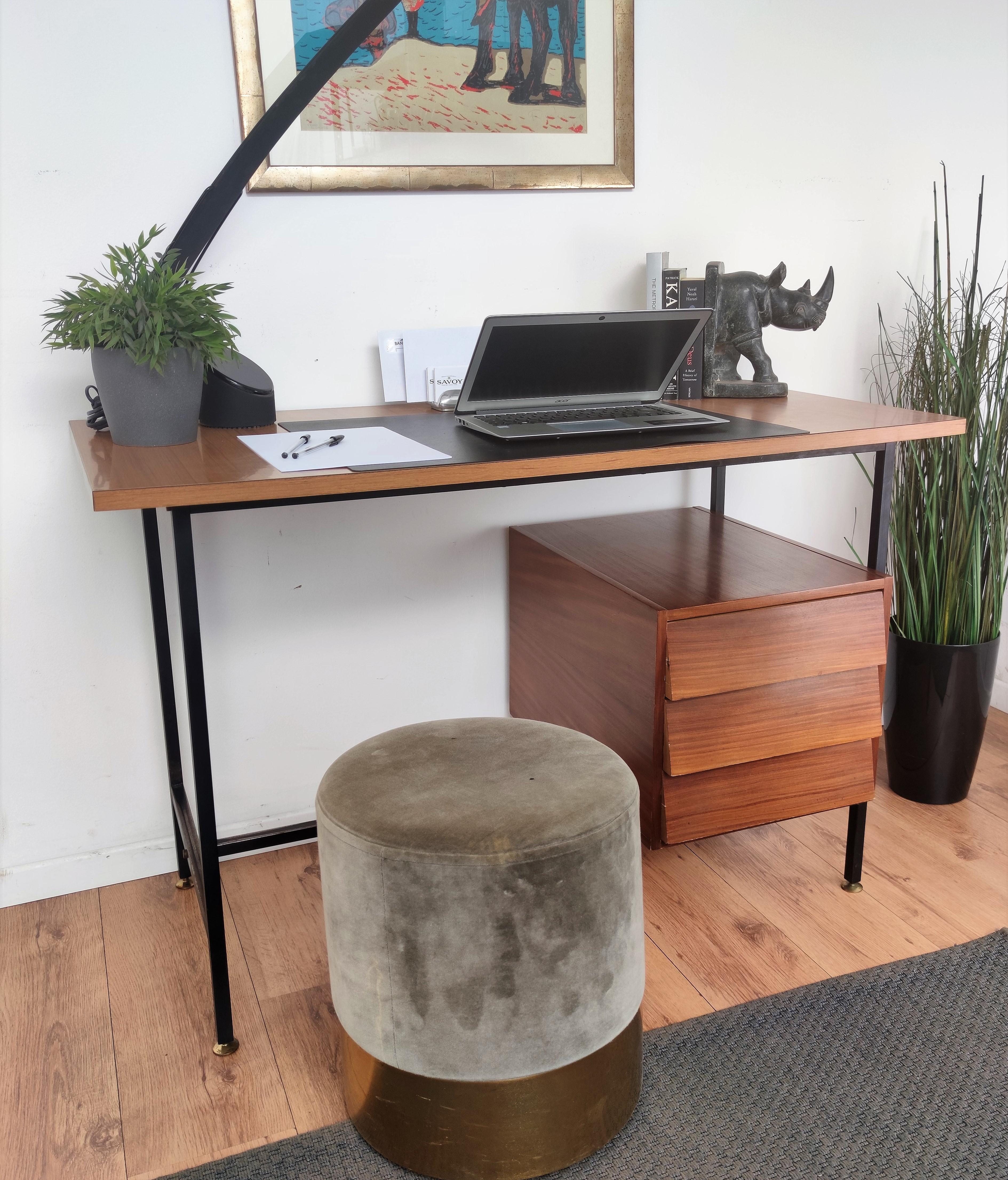 Typical Italian Late Mid-Century Modern desk or writing table in black metal cross bar base structure with gilt brass feet, 3 side wooden drawers and wooden top. Ideal in any room as a small stand alone corner desk as well as next the wall.