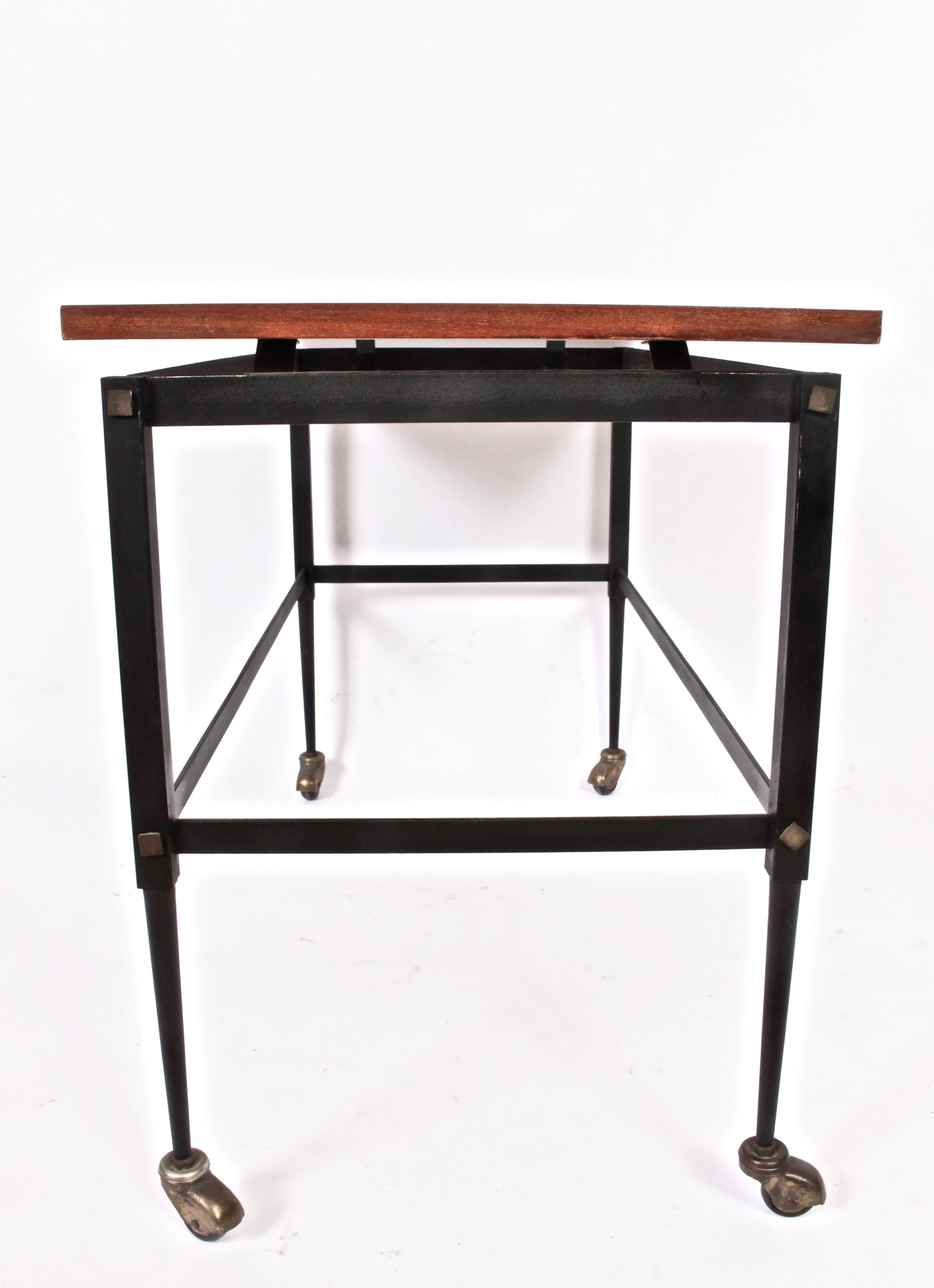 Italian Modern Black enameled Iron Bar Cart with floating Teak Surface. Versatile use as: Serving Cart. Higher Coffee Table. Nightstand, Smaller TV Table. Features a narrow and open rectangular framework, solid Teak surface, Brass hardware and four