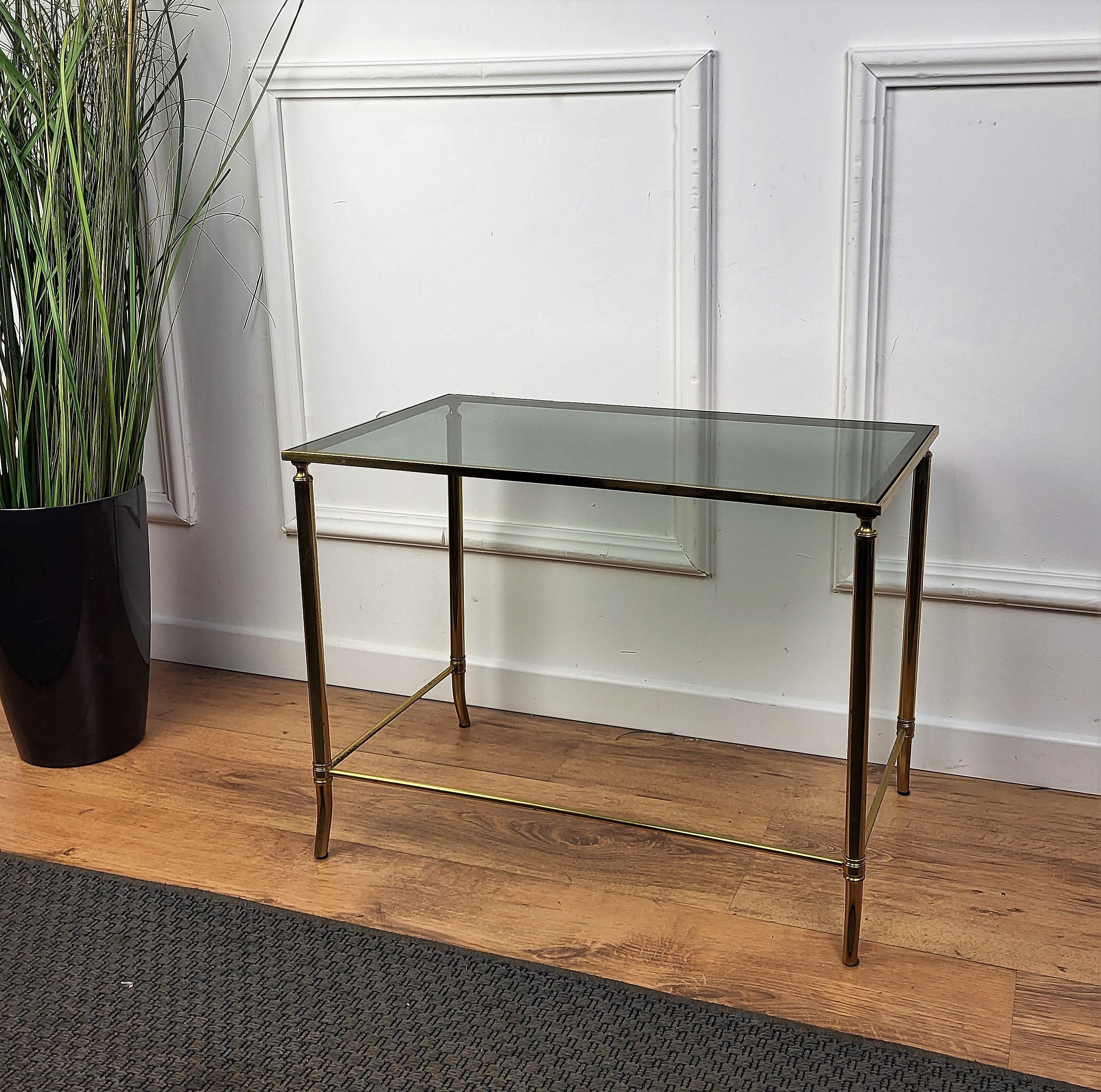 Beautiful and stylish vintage 1980s Italian brass and smoked side table or coffee table or sofa table. Very good condition with great brass and glasses. A great piece that perfectly adds to every home decor the typical glitz, glamour and gold of