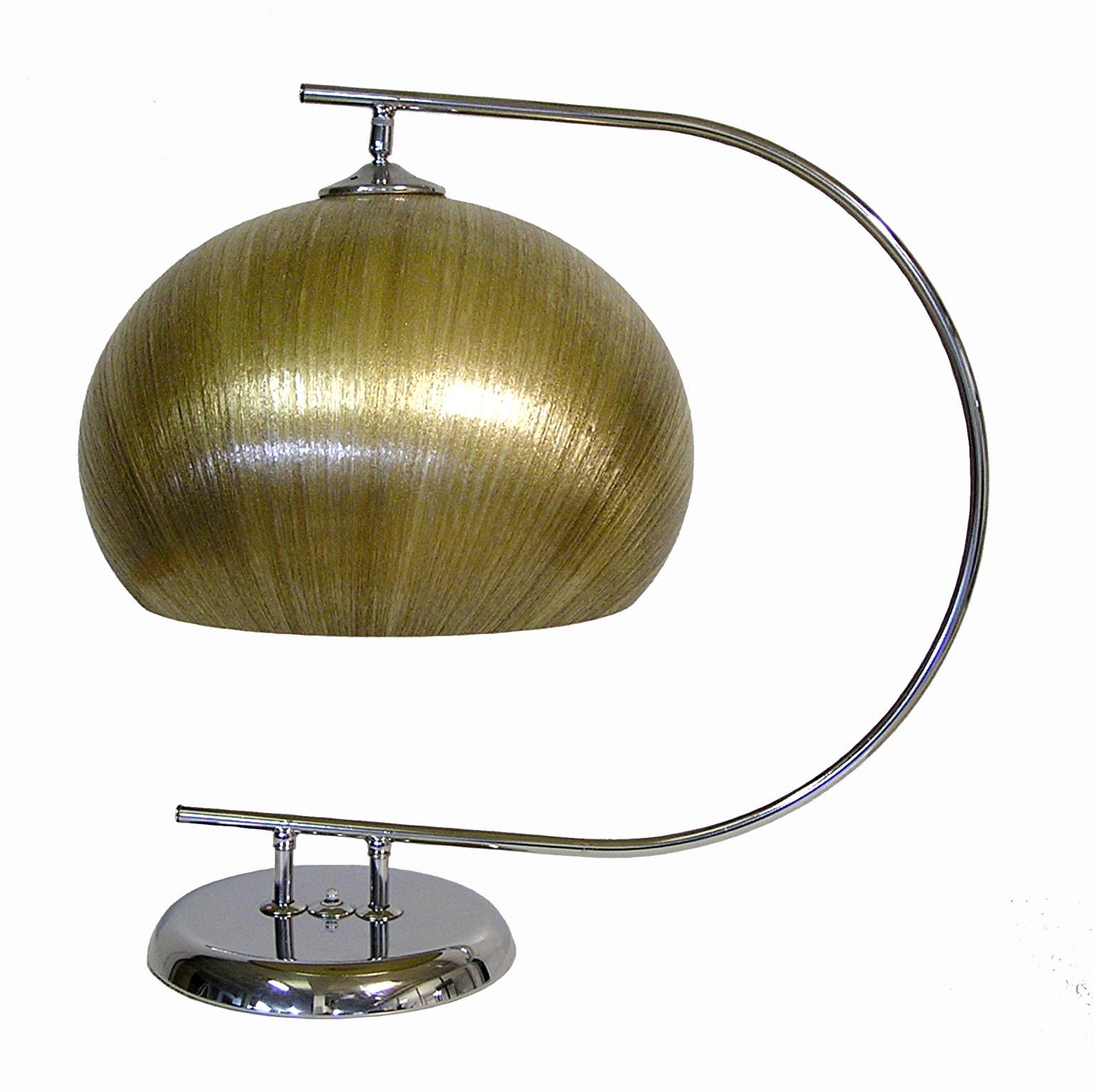 A gorgeous pair of chrome table lamps with spun fiberglass shades from the 1960s attributed to Harvey Guzzini of Italy. Stunning Italian Modern design featuring an arched tubular chrome shaft set on an elliptical base and fitted with a large spun