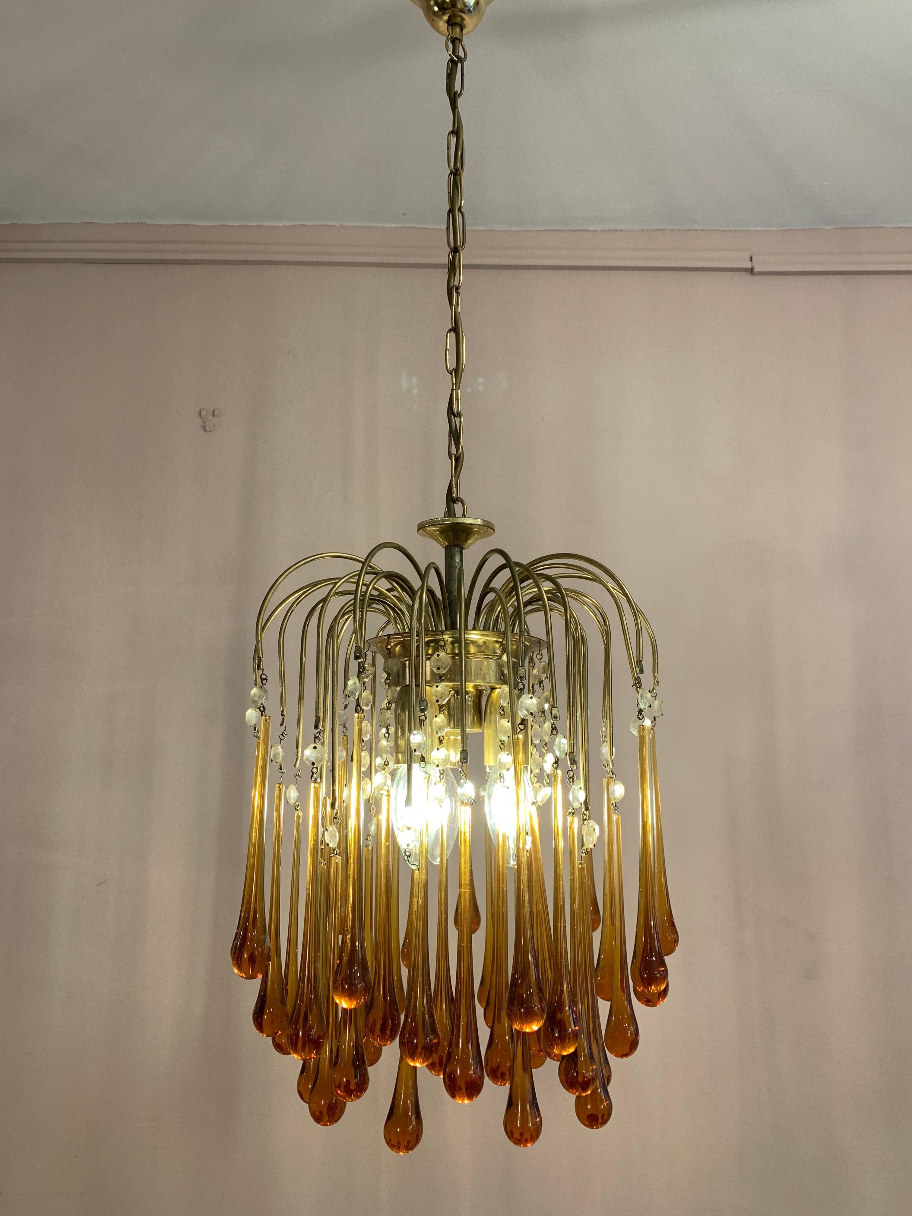 Vintage 1960s Italian Murano, amber-glass, cascading, chandelier designed by Paolo Venini. There are three-tiers of amber glass teardrops suspended from brass stems with clear glass pearls dividing the two.

Three E14 screw-in bulbs sit under the