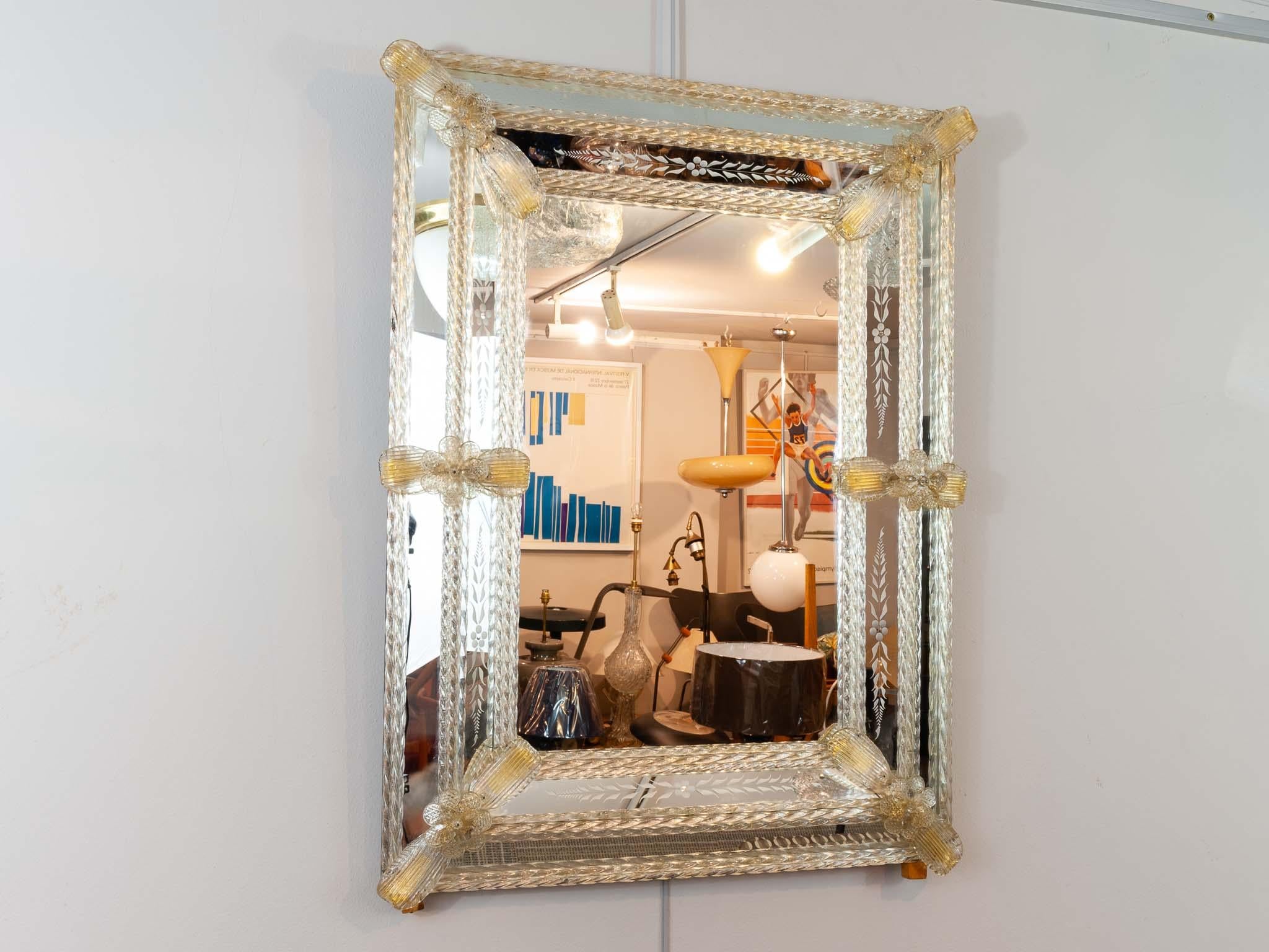 An Italian Venetian mirrored glass wall mirror with reversed etched panels, glass flowers and finely twisted glass rods over subtle gold foil. Perfect for a small dressing or powder room. A beautifully made an intricate mirror.

Dimensions: Depth
