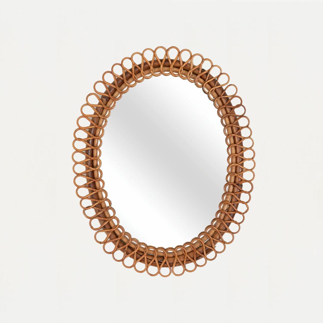 Beautiful rattan mirror in an oval shape from Italy, 1960's. Unique design with tightly looped rattan detailing encompassing the mirror. Statement piece perfect for bathroom or entryway. Nice vintage condition with original coloring.