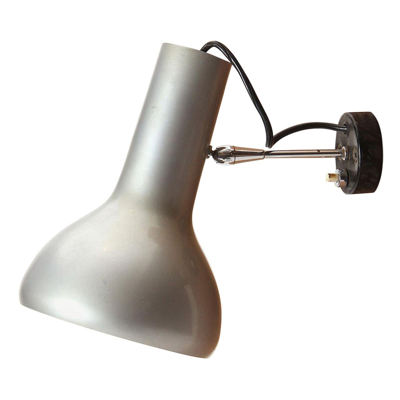 A pair of adjustable wall sconces having natural aluminum shades extending on a slim steel stem with a push-switch mount.