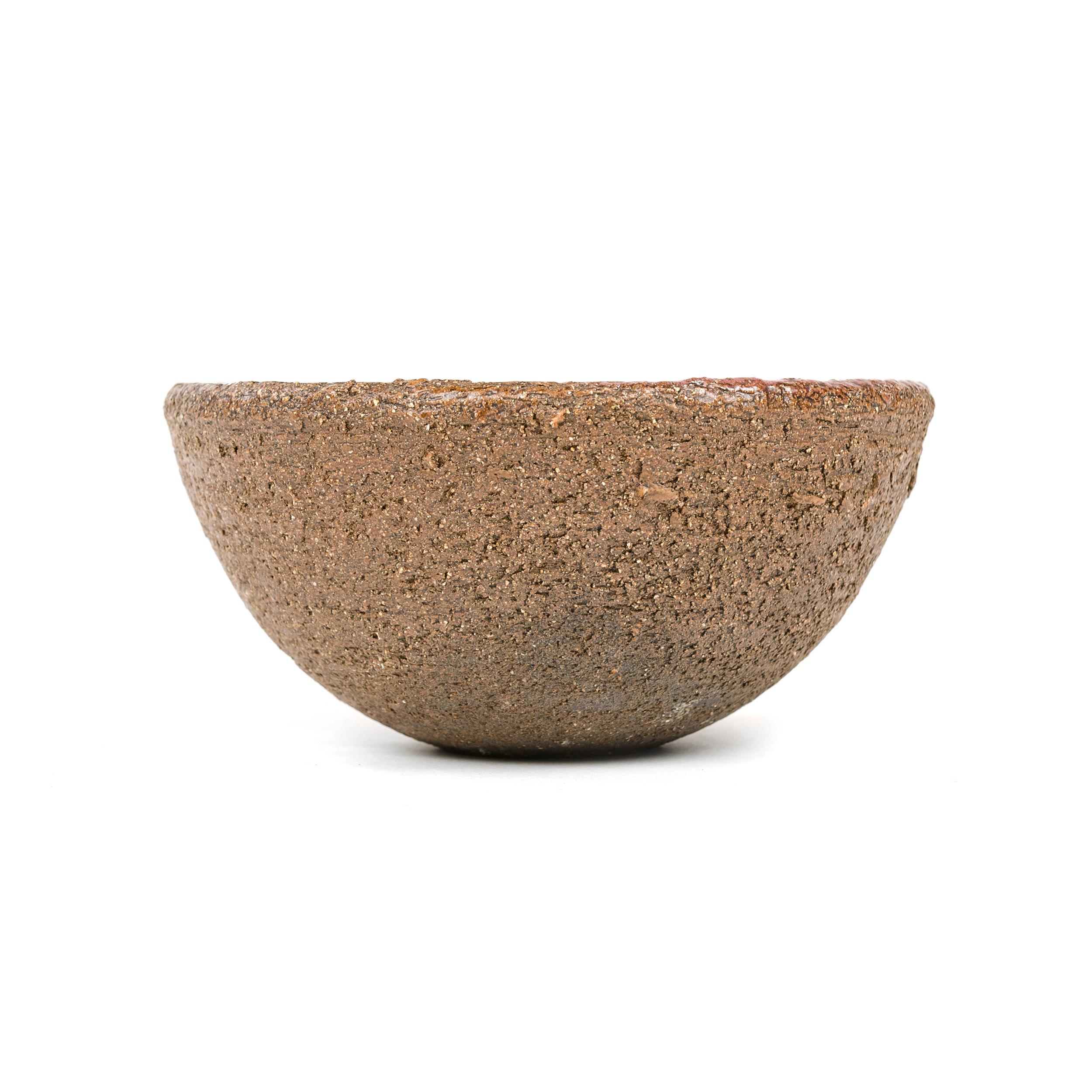 A small, hand-thrown, groggy stoneware bowl with half-dipped glossy rose glazed interior. Marked 282 H, Italy.