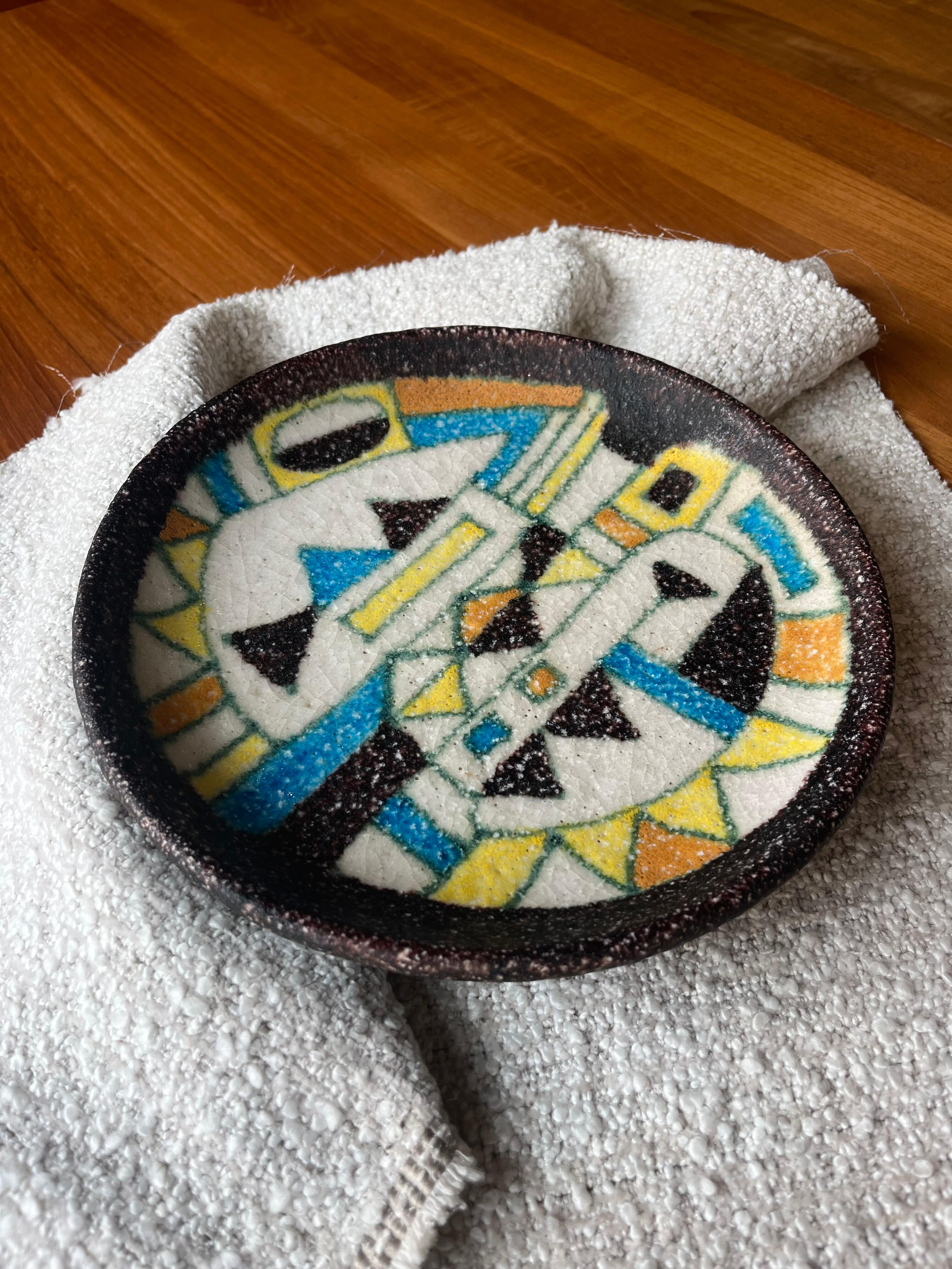 We are excited to offer this 1960s plate by Guido Gambone, showcasing his signature craquelure glaze that adds a unique, crackled texture to its surface. With rich texture and vibrant hues, the bowl features beautiful colors and dynamic patterns,