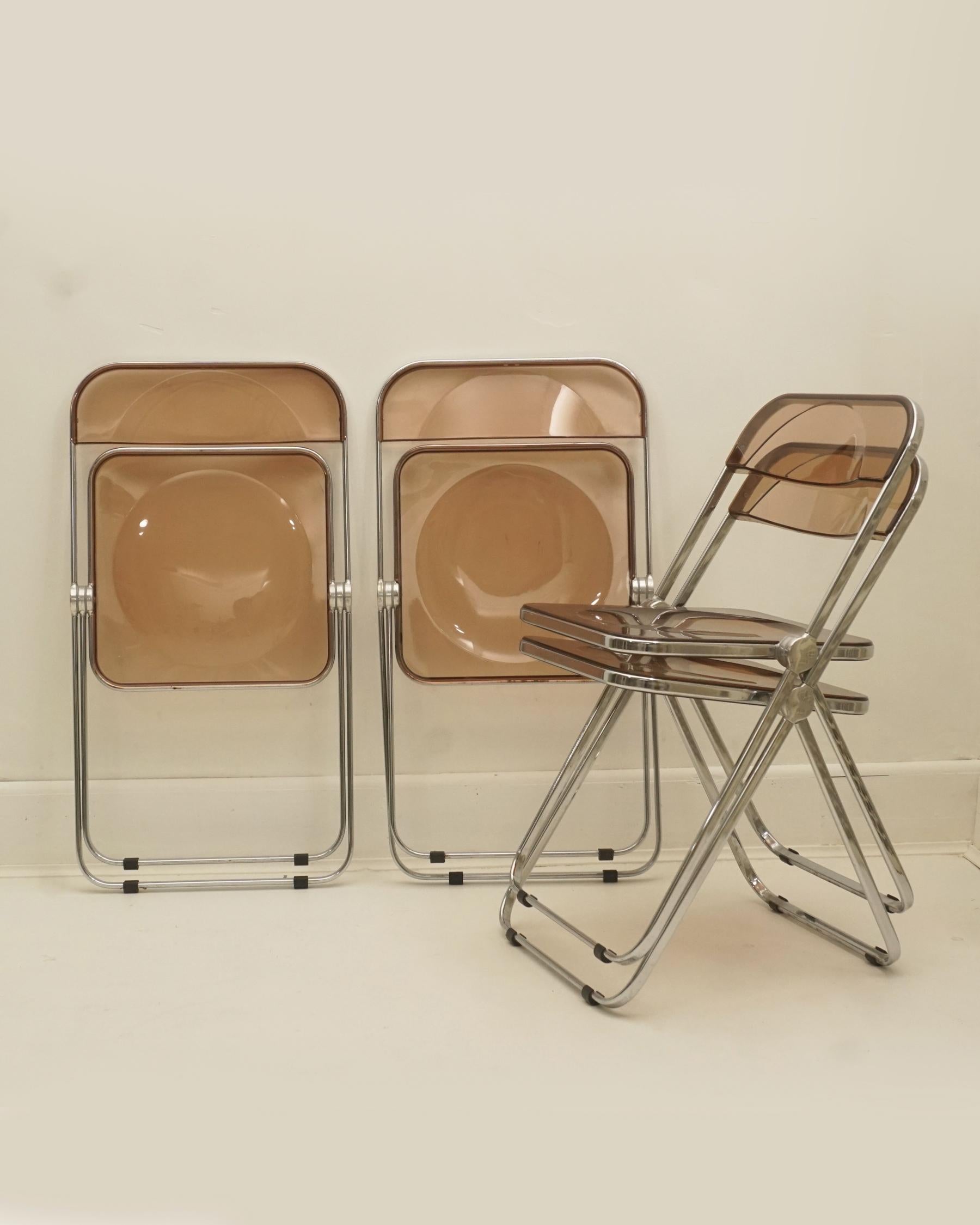 1960s folding chrome and smoke bronze lucite chairs by Giancarlo Piretti for Castelli. Made in Italy. Labeled on underside of each chair. Very good condition with some minimal scuffs. Four available and sold individually.