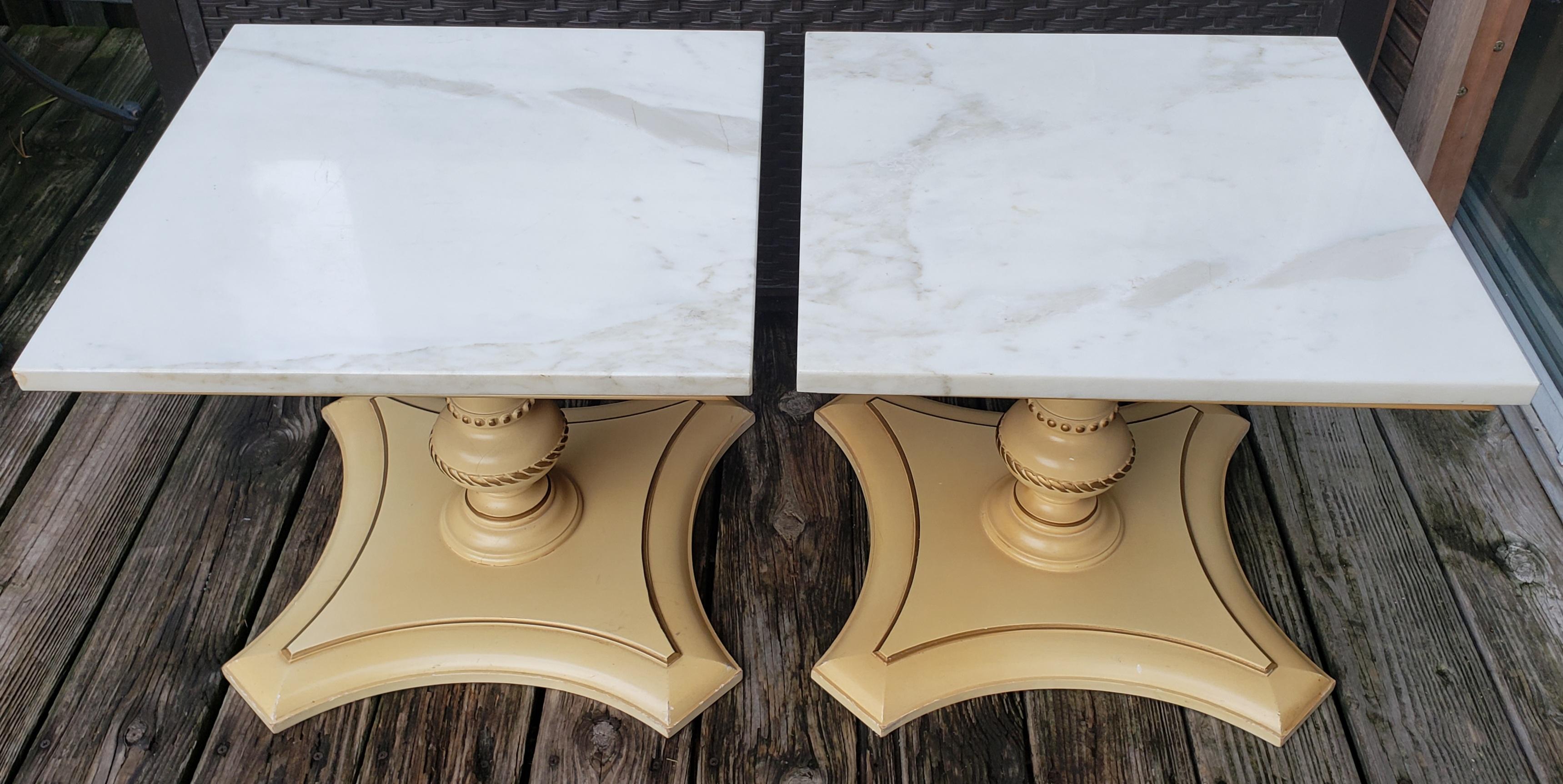 These tables they are absolutely beautiful. They date back to at least the 1950-60s

Solid polished antique white carrara marble with neoclassical square pedestal bases with stylish partial gilt lines.
The shape is very transitional as they are