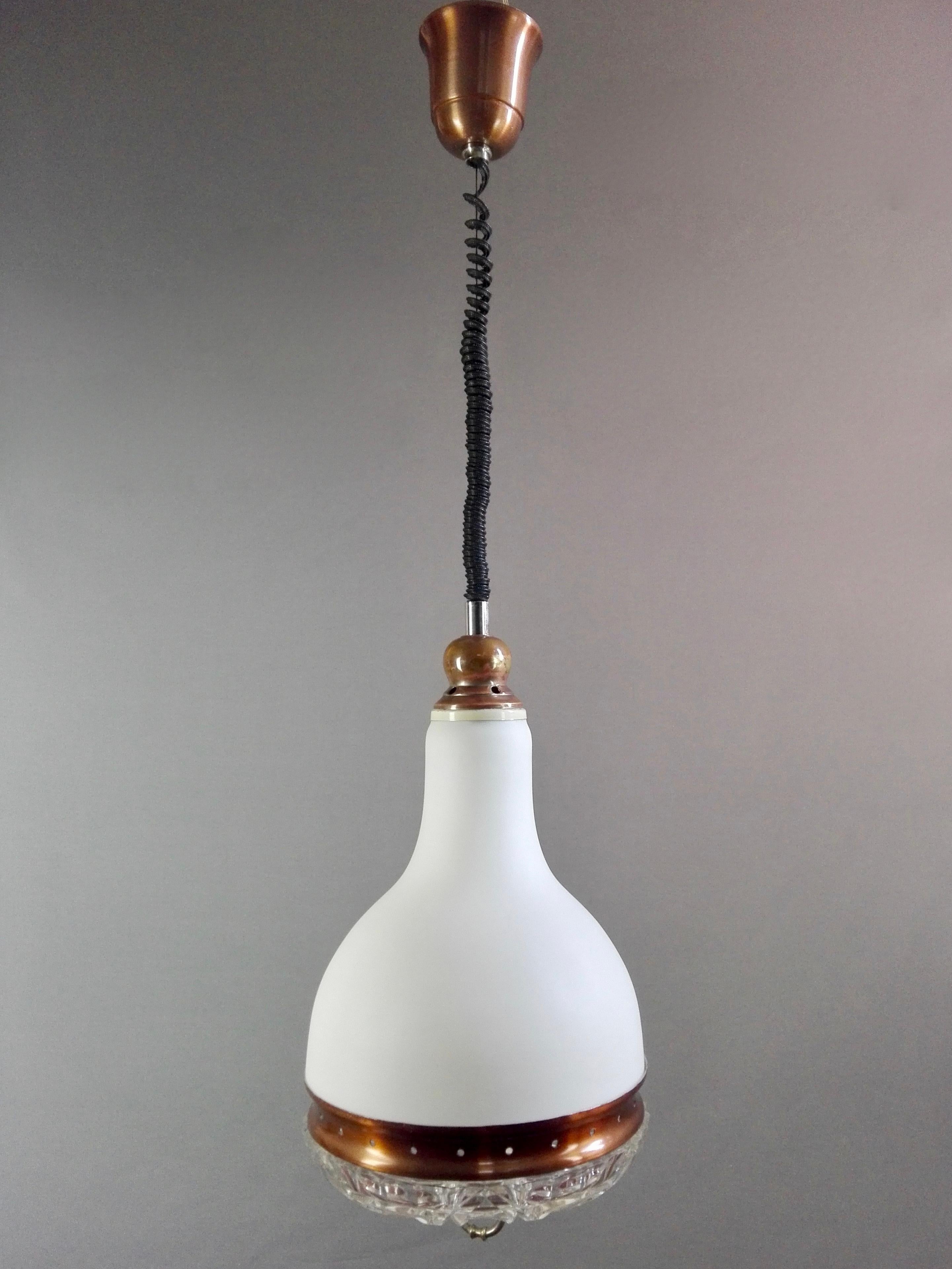 Three-light rise-and-fall Murano glass pendant lamp from the 1960s, Italy. The upper part of the light is in cased white opaline glass. At its base is closed by a solid glass plate that has an elaborate and fascinating workmanship, with regular