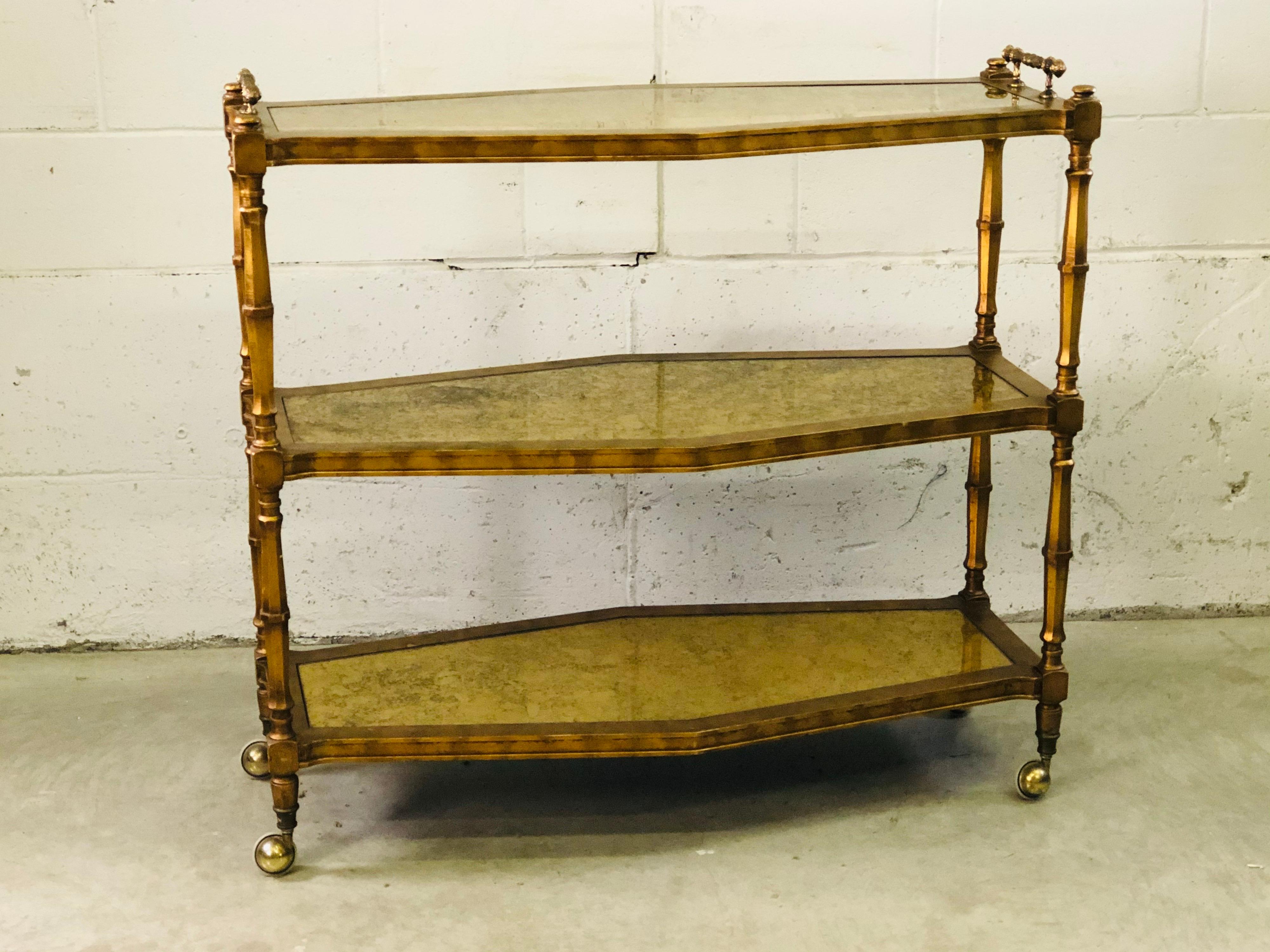 Vintage 1960s Italian three-tier rolling serving cart with gold glass inserts and ornate metal handles. The cart has matching gold paint on the wood and the castors roll perfectly. No marks