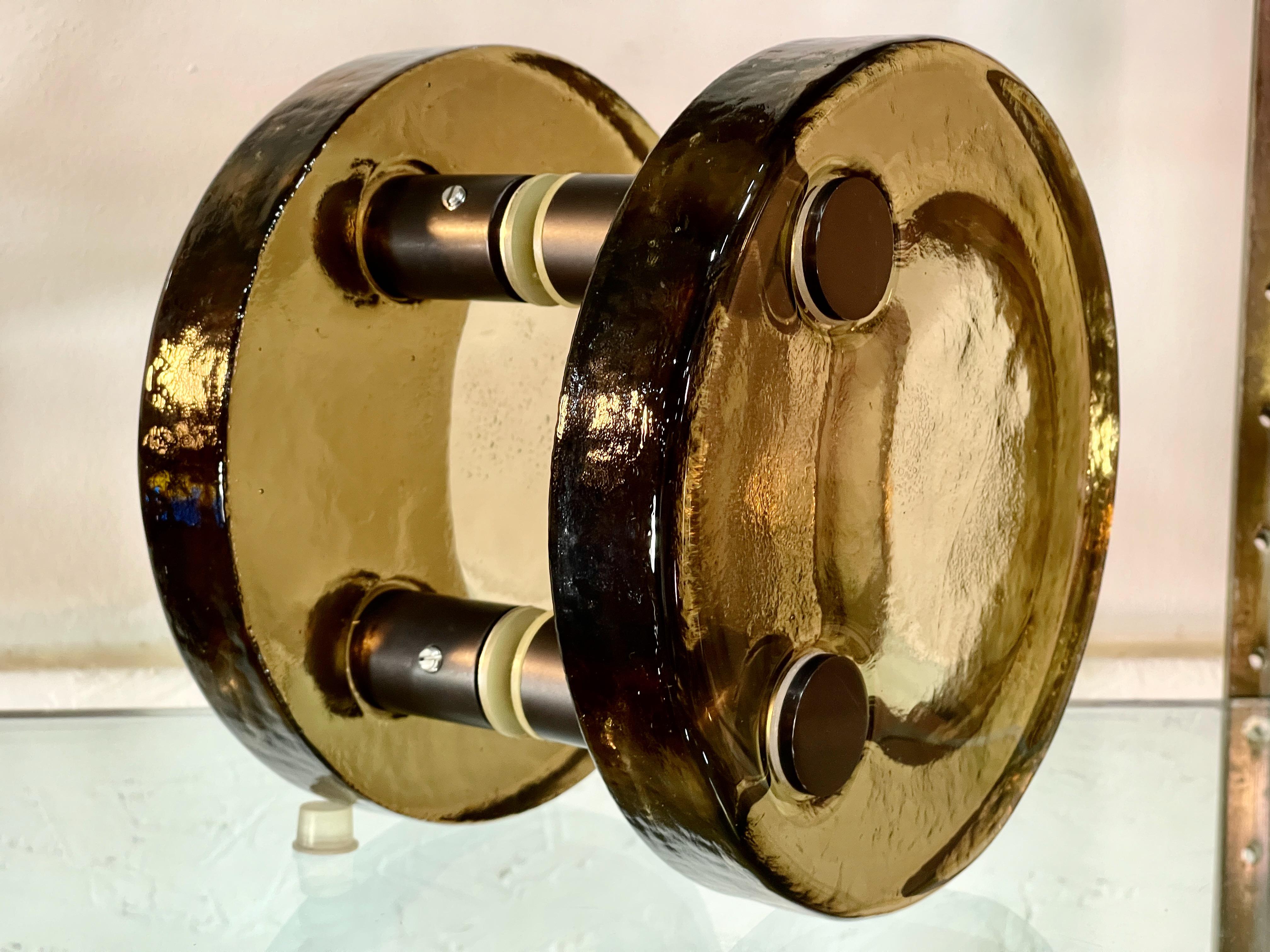 Highly stylized almost space age architectural double door pull made of  smoked charcoal/brown thick cast glass and black anodized hardware. Very good.