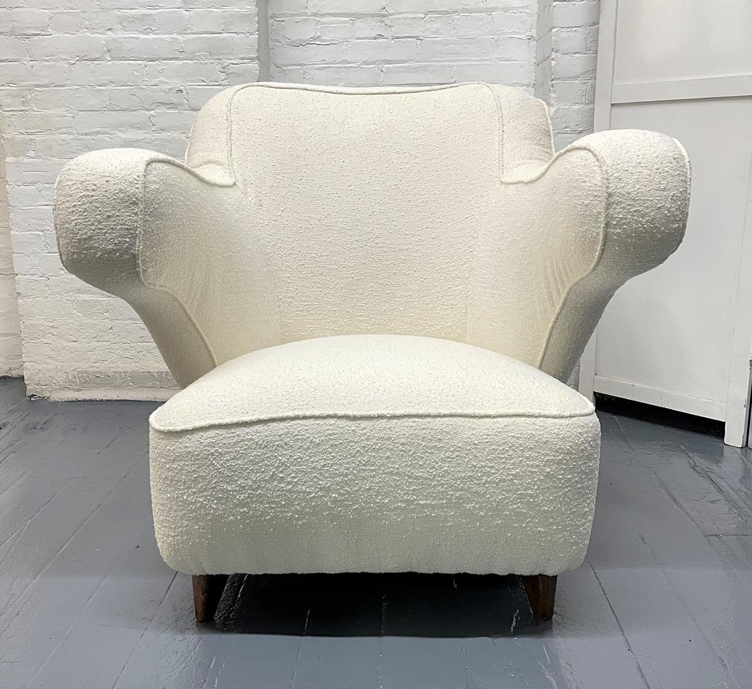 1960s Italian sculptural lounge chair upholstered in Boucle. The chair has a sculptural shape with solid walnut legs.