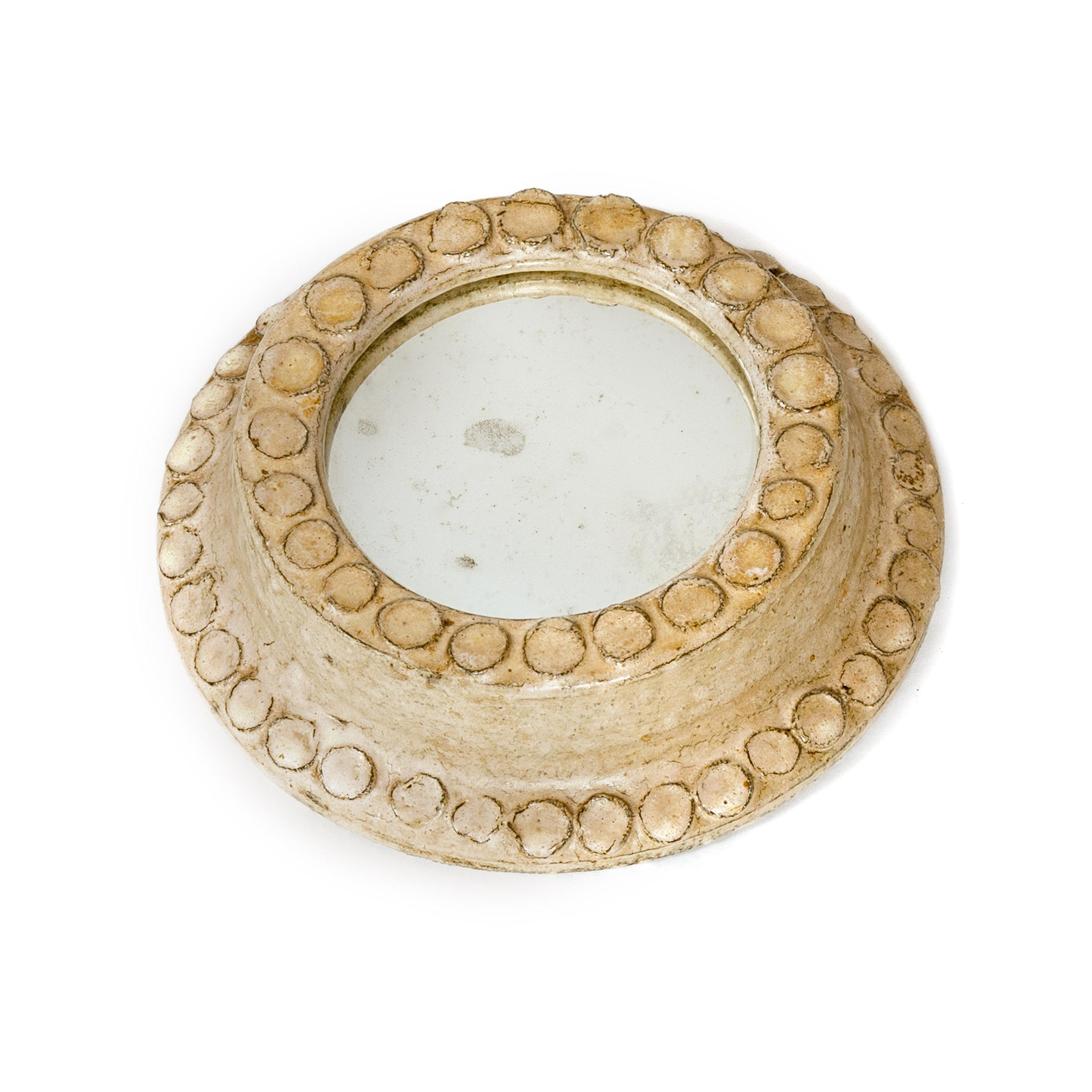 A petite, artisan crafted, hand-thrown diminutive wall mirror with an off-white hand applied glaze. On the mirror’s reverse are two nicely crafted loops to string mounting wire and the glass is backed with marbleized paper. No visible identifying