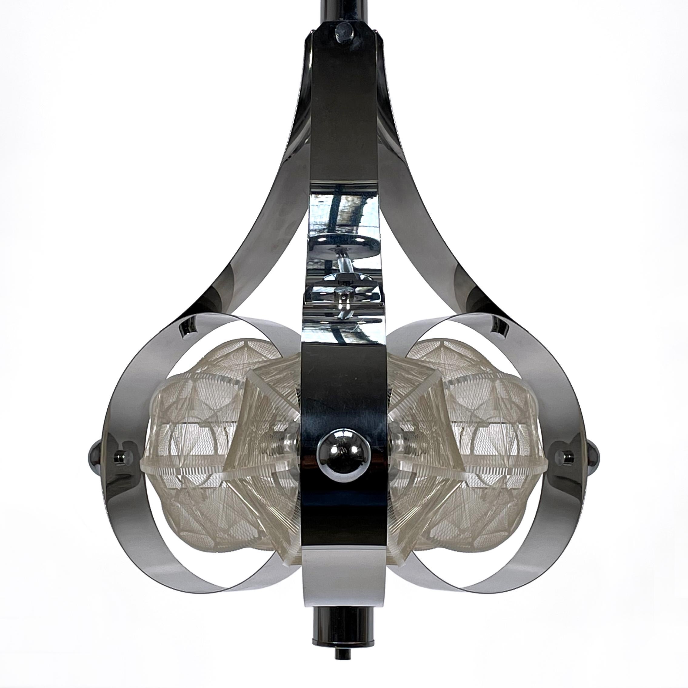 Large and stunning Space Age pendant light made of chrome, plexiglass and nylon thread from the 1960s / 1970s.
The stylish and elegant Mazzega-meets-Secon hanging lamp has three large circular chrome bands, each surrounding a beautiful shade made of
