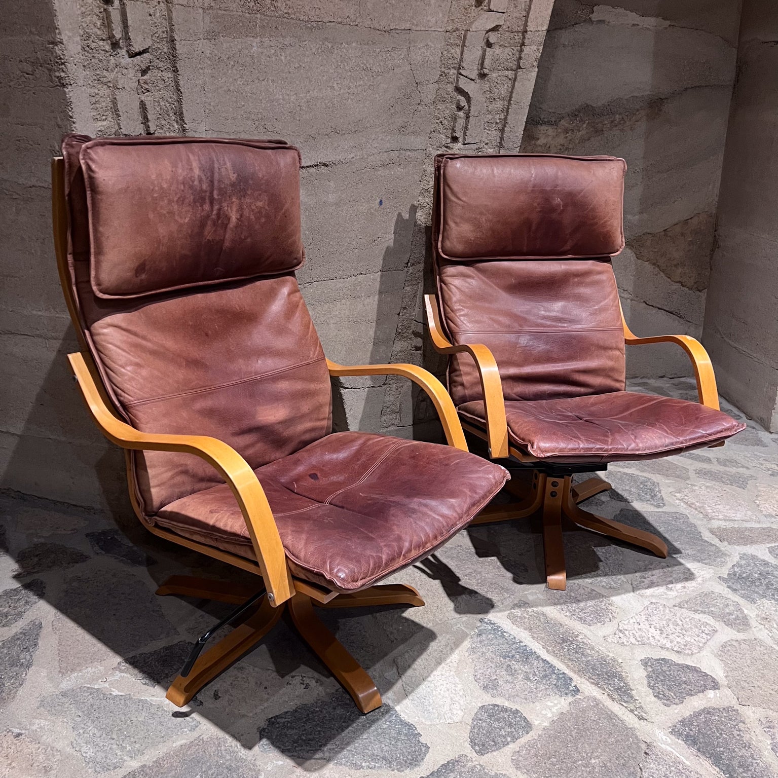 1960s Italian Swiss Leather Padded Tall Lounge Chairs
Wood Star Base
Made in Italy manner of De Sede.
Unmarked
41 tall x 31 d x 25.5 w Seat h 17 arm h 23
padded high back comfort.
Brown leather cover with fabulous aged patina.
Original unrestored