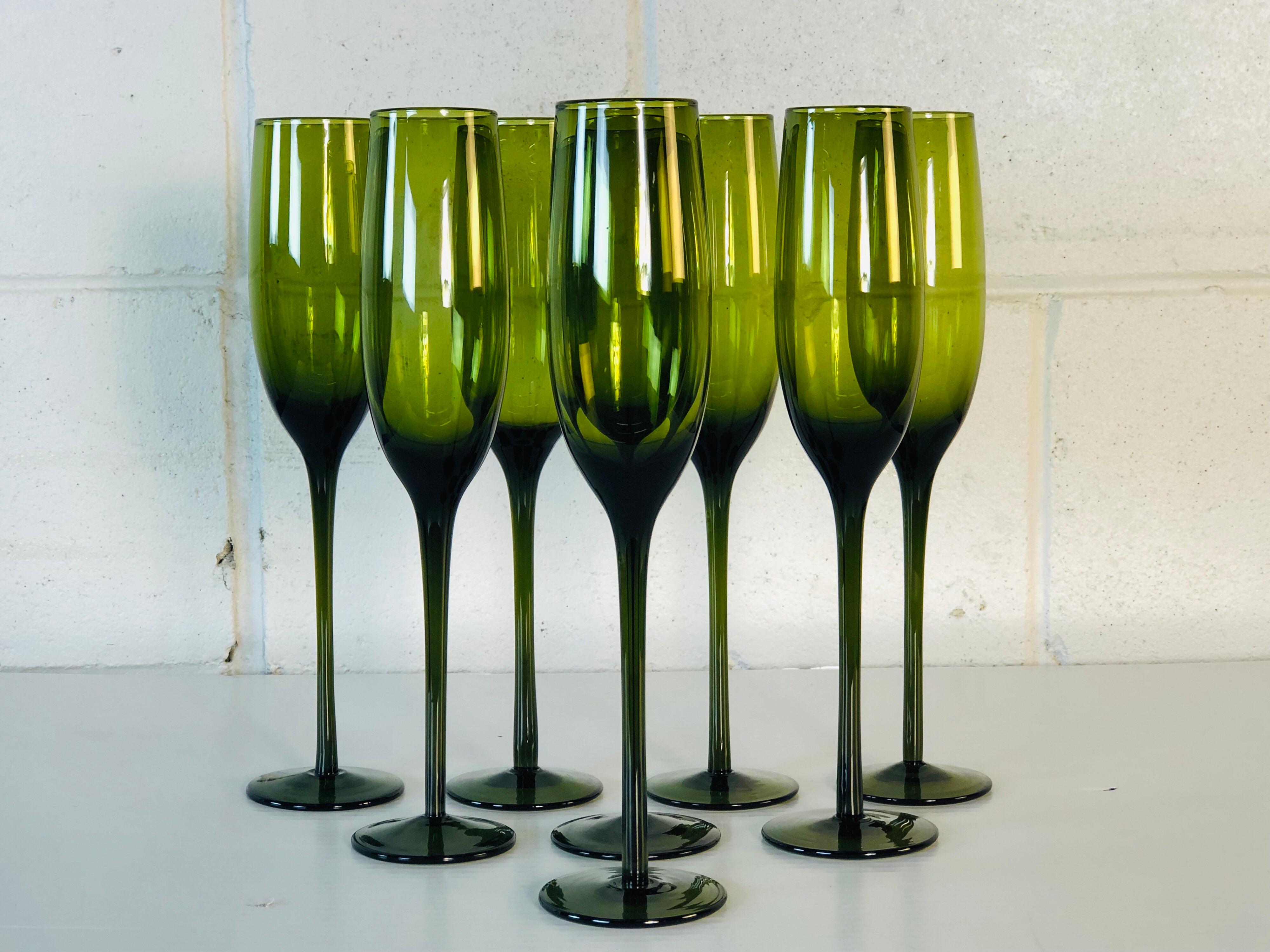 1960s Italian tall delicate green glass set of 8 champagne flutes. This set of stems is elegant and delicate glass. They will be a great addition to any party! Excellent condition. No marks.