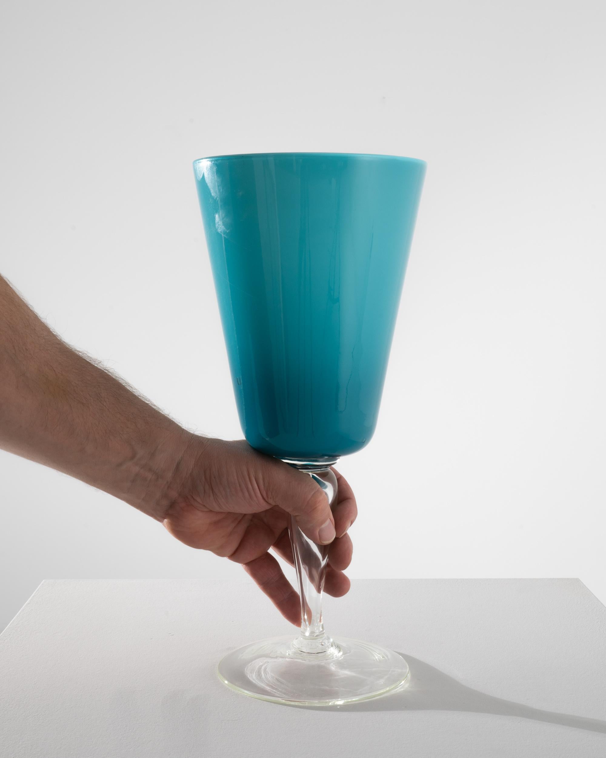 Elevate your dining experience with this stunning Italian Teal Glass Goblet from the 1960s, a true gem for collectors and enthusiasts of mid-century design. This goblet exudes sophistication with its rich teal color that suggests the depth of the