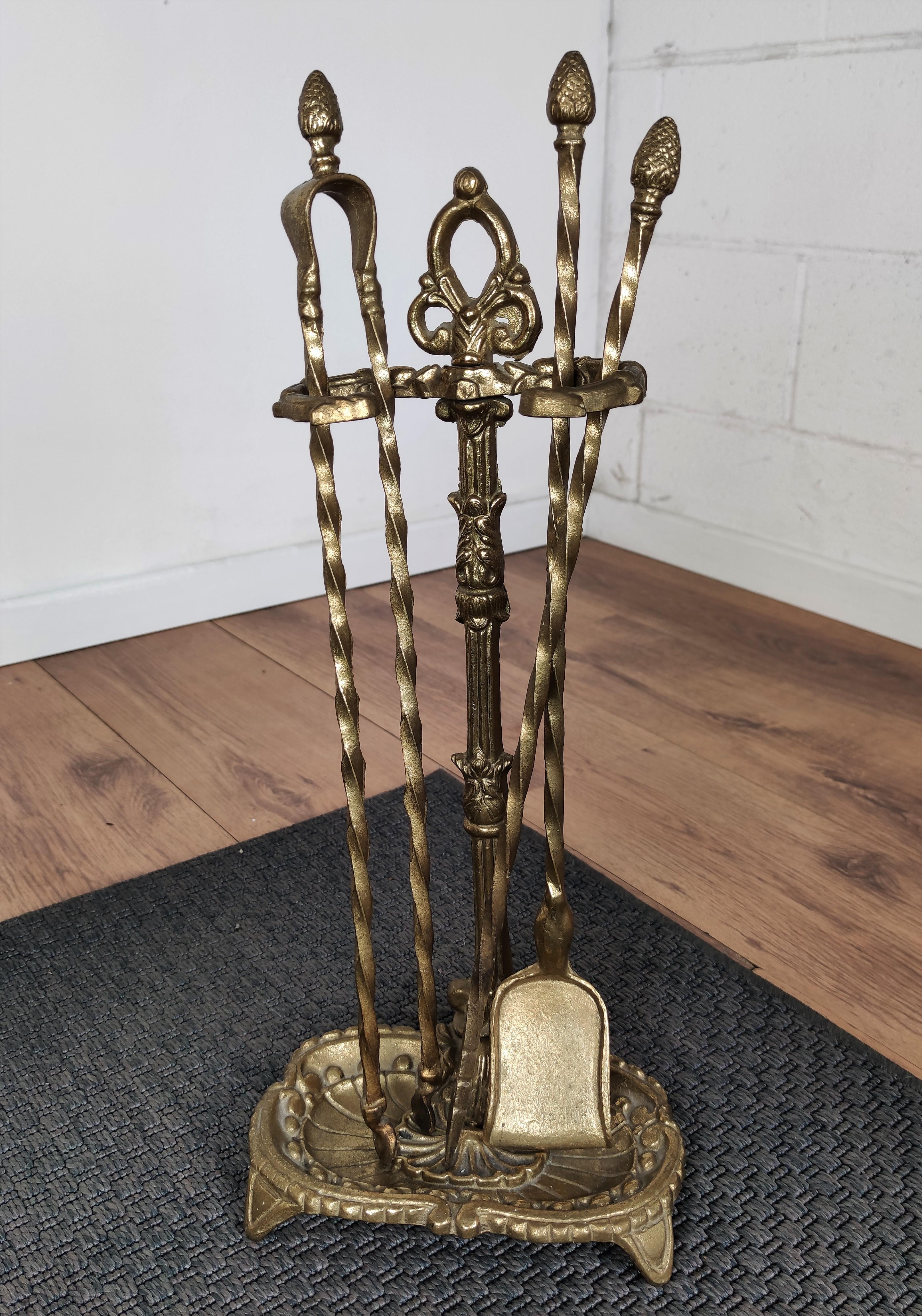 Midcentury Italian vintage brass three-piece fire tool set with stand. The set consists of a poker, a shovel and a pair of tongs, each with an ornate acorn handle such as the stand.