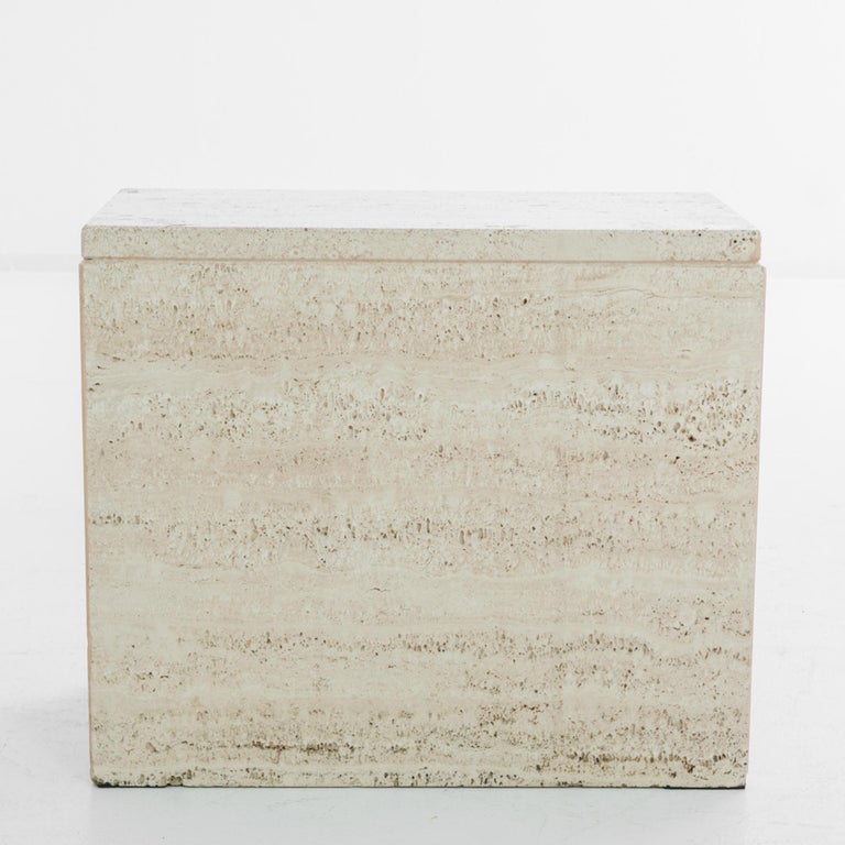 This stone coffee table was made in Italy, circa 1960. The solid block of the silhouette is articulated by the clean edges of the travertine slabs. The speckled neutral color and luminous, liquid veining of the polished surface create a natural