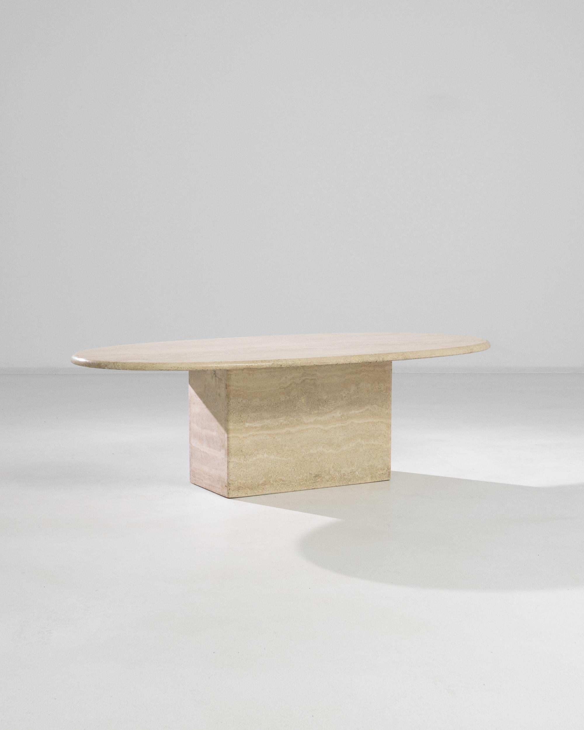A cantilevered slab of textured travertine rests on a rectangular base in this stylish and simple coffee table. The tabletop is carved with a rounded edge profile.

Stone is a material rich in itself. Echoing classical sculpture, a design that's