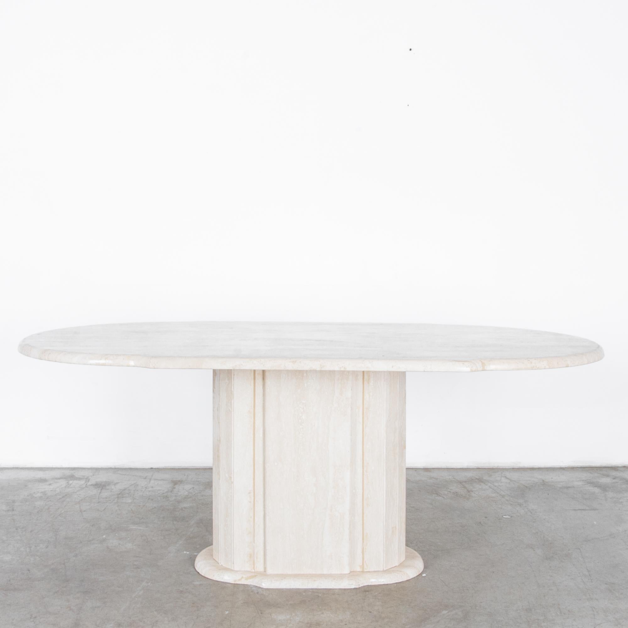 A cantilevered slab of light travertine rests on a faceted round base in this stylish and simple dining table. The tabletop is carved with rounded edge profile.

Stone is a material rich in itself; echoing classical sculpture, a design that's