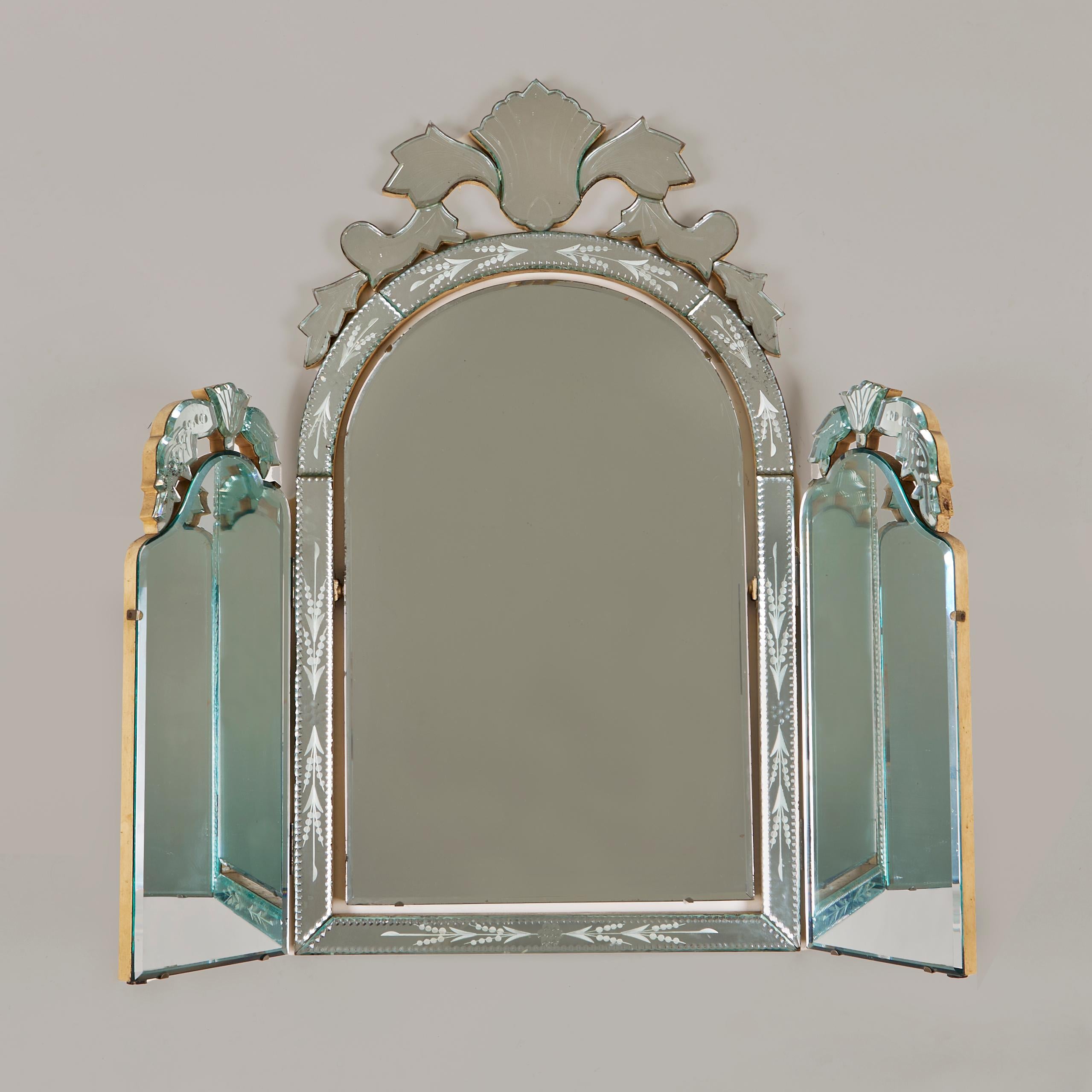 Substantial and elegant bevelled triple mirror with decorative bevelled etched glass frame and crests. Central mirror is adjustable for ease of use. Wooden back. Excellent condition. Original glass shows some signs of foxing as is to the expected