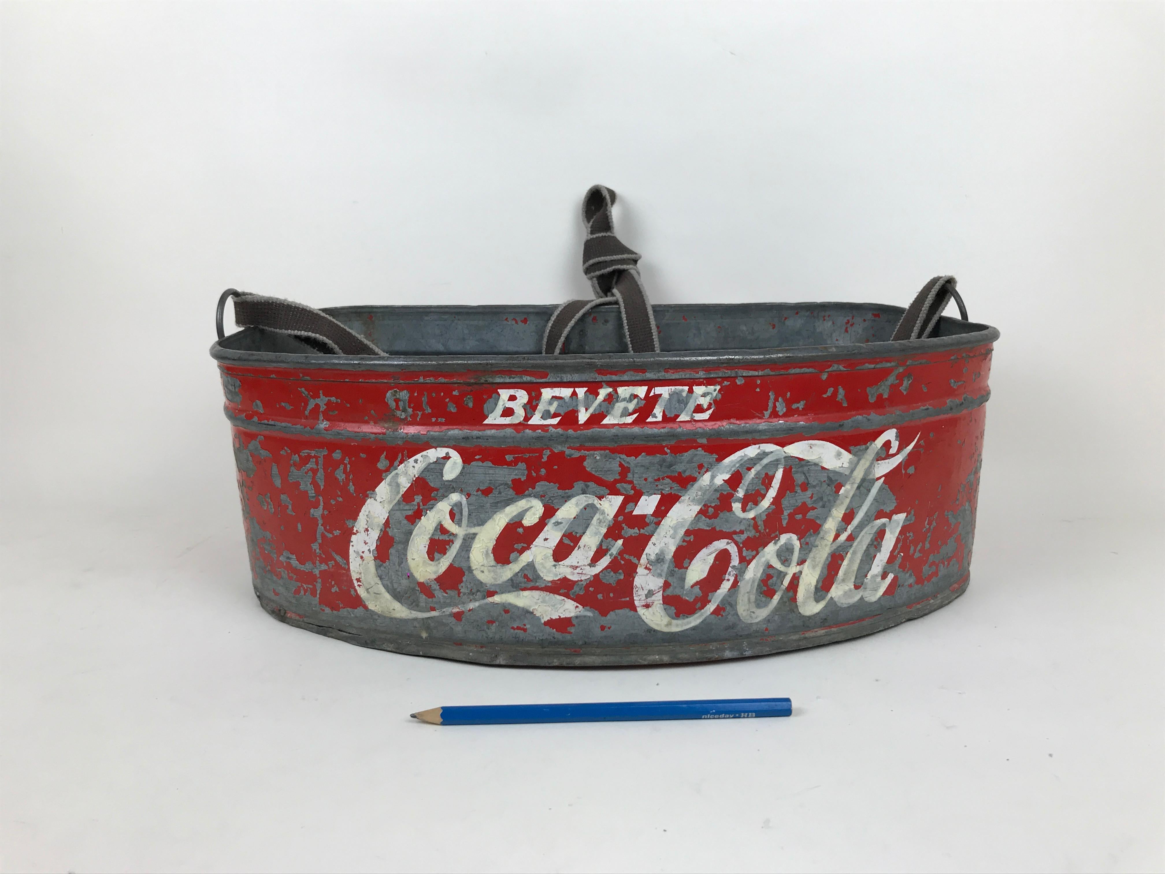 This vintage metal Coca-Cola vending tray, in red and white, was used in the 1960s in Italy to sell Coca-Cola's sodas during sport events at stadiums. 

The front of the cooler shows the company motto 