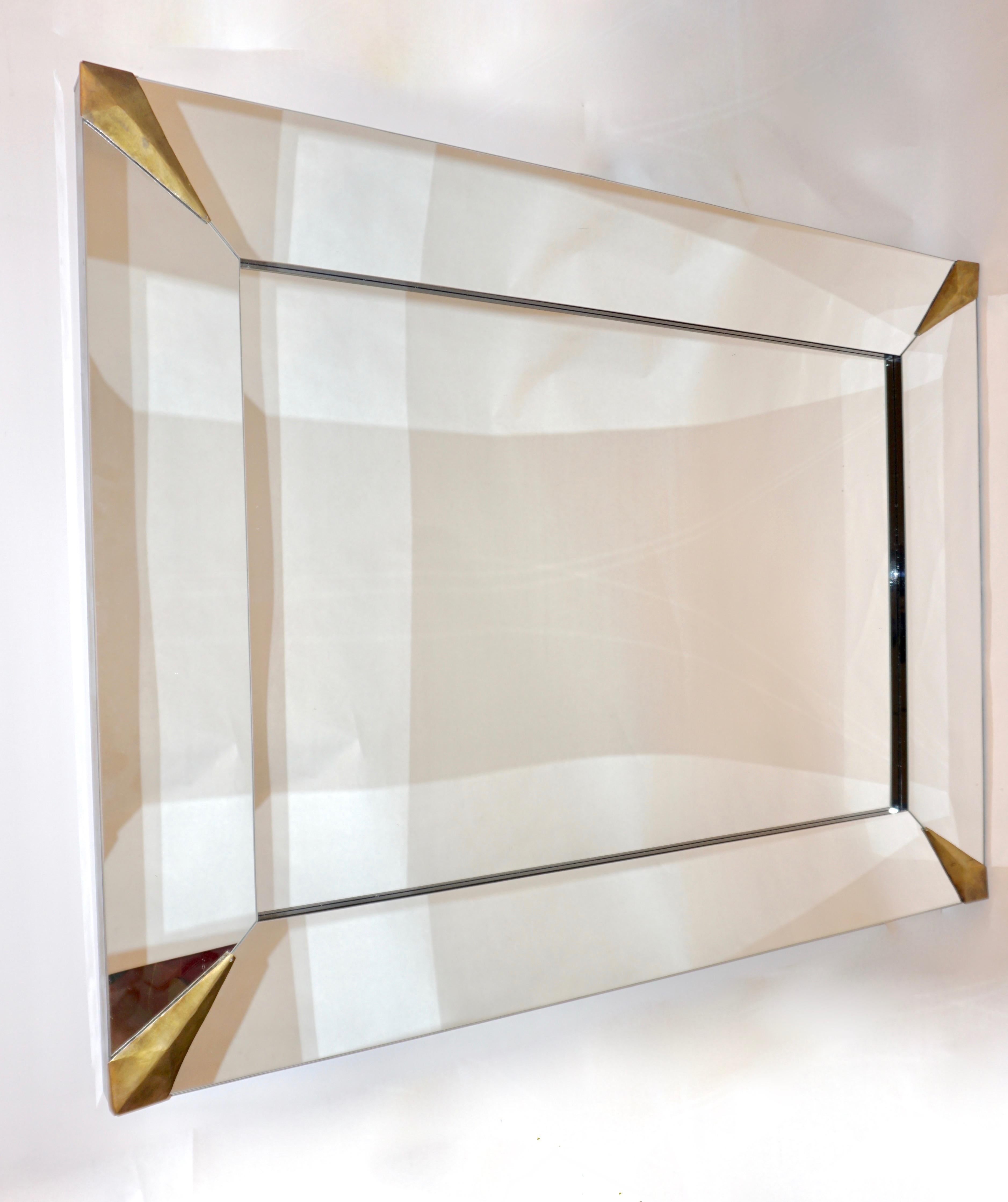 1960s Italian Mid-Century Modern rectangular mirror, entirely handmade with handcrafted and hammered brass corner mounts. High quality of construction with the sides highlighted by a black Murano glass border all the way round as well as the inside