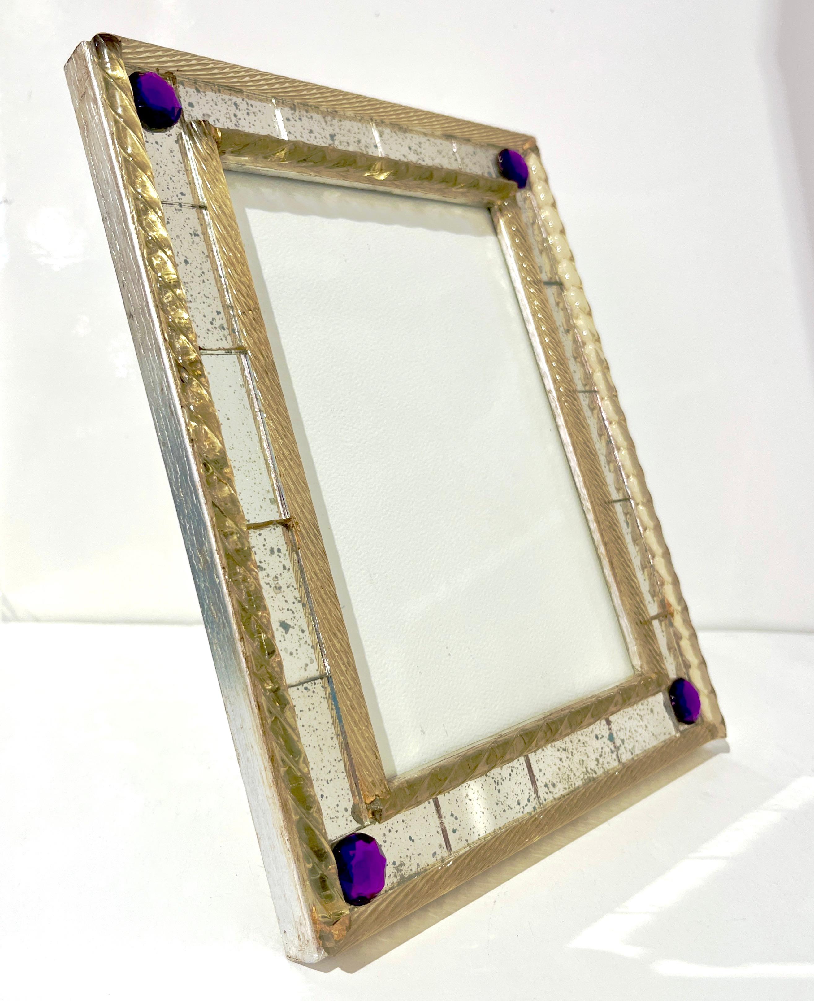 A 1960s elegant Italian vintage picture frame to add style and simple sophistication to any room. The vintage speckled mirrored frame is double-edged in relief by twisted amber glass baguettes with two different types of twists and decorated at each