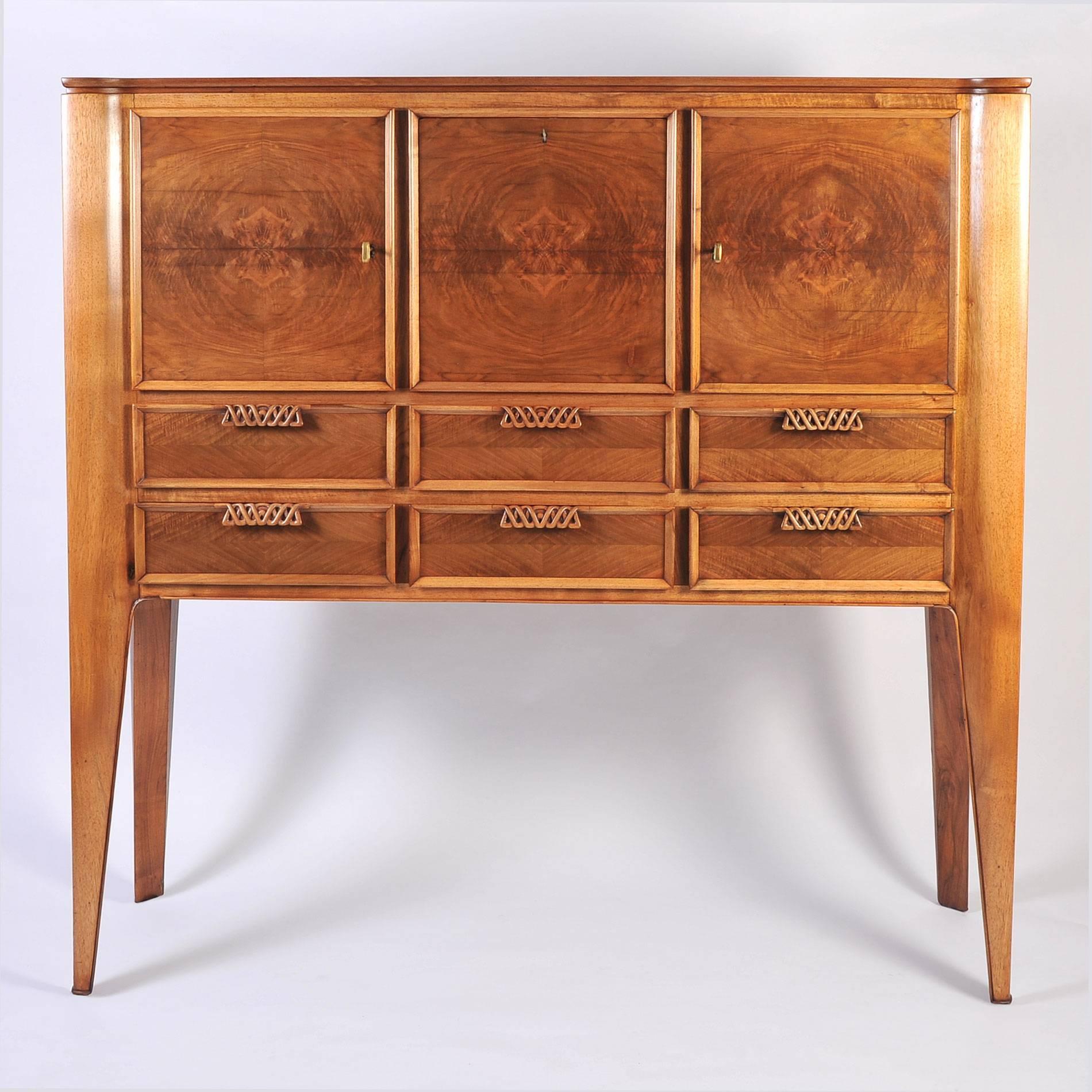 Beautifully carved walnut cabinet by Paolo Buffa. Features three upper cupboards with original keys (left and right cupboards open from the side, the middle cupboard opens downwards) and six lower drawers with decorative carved twisted handles.