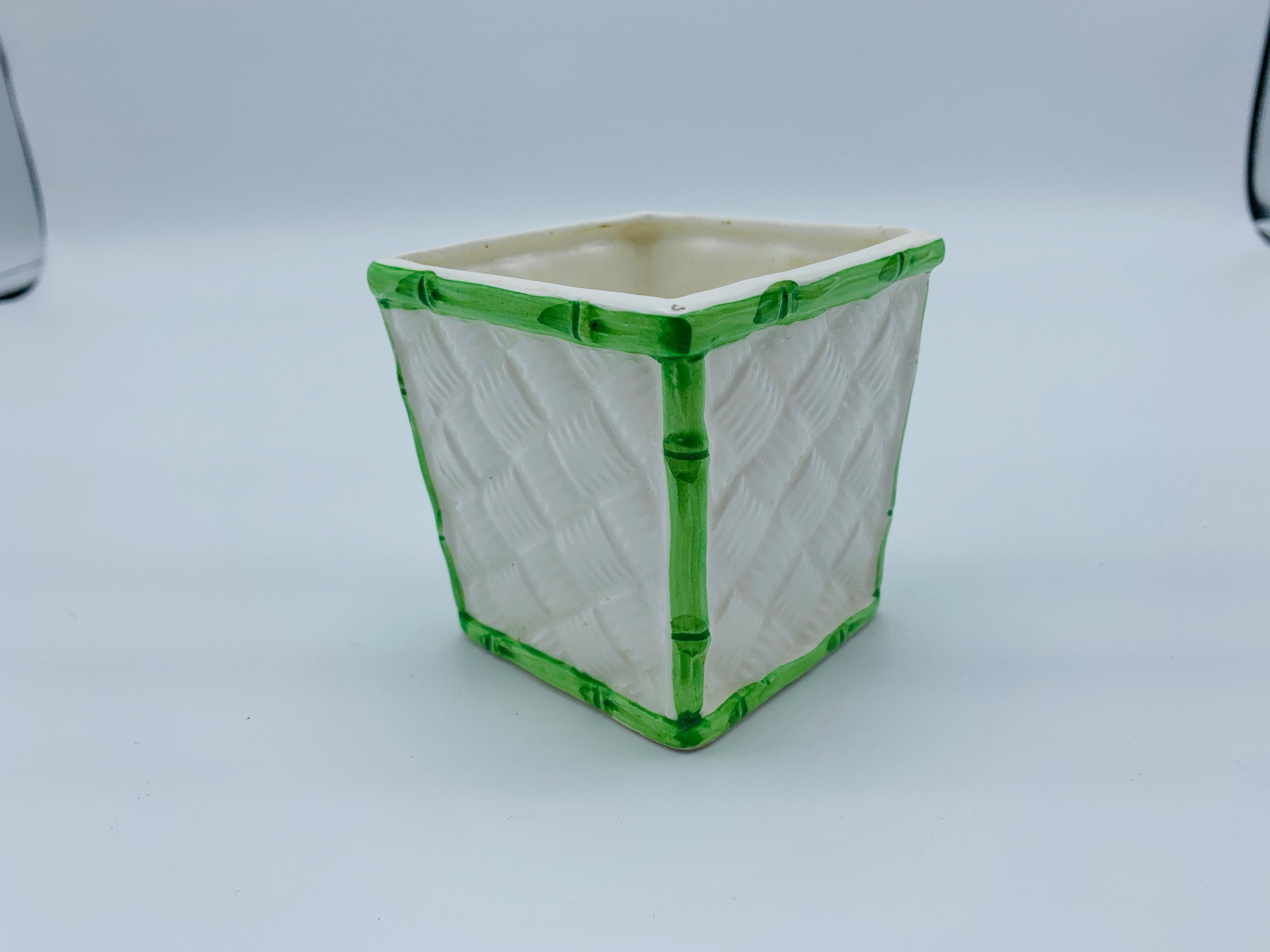 Listed is a fabulous, 1960s miniature Italian ceramic cachepot. The piece has a beautiful, white basketweave pattern on all four sides with a green faux bamboo border. Measures: 3