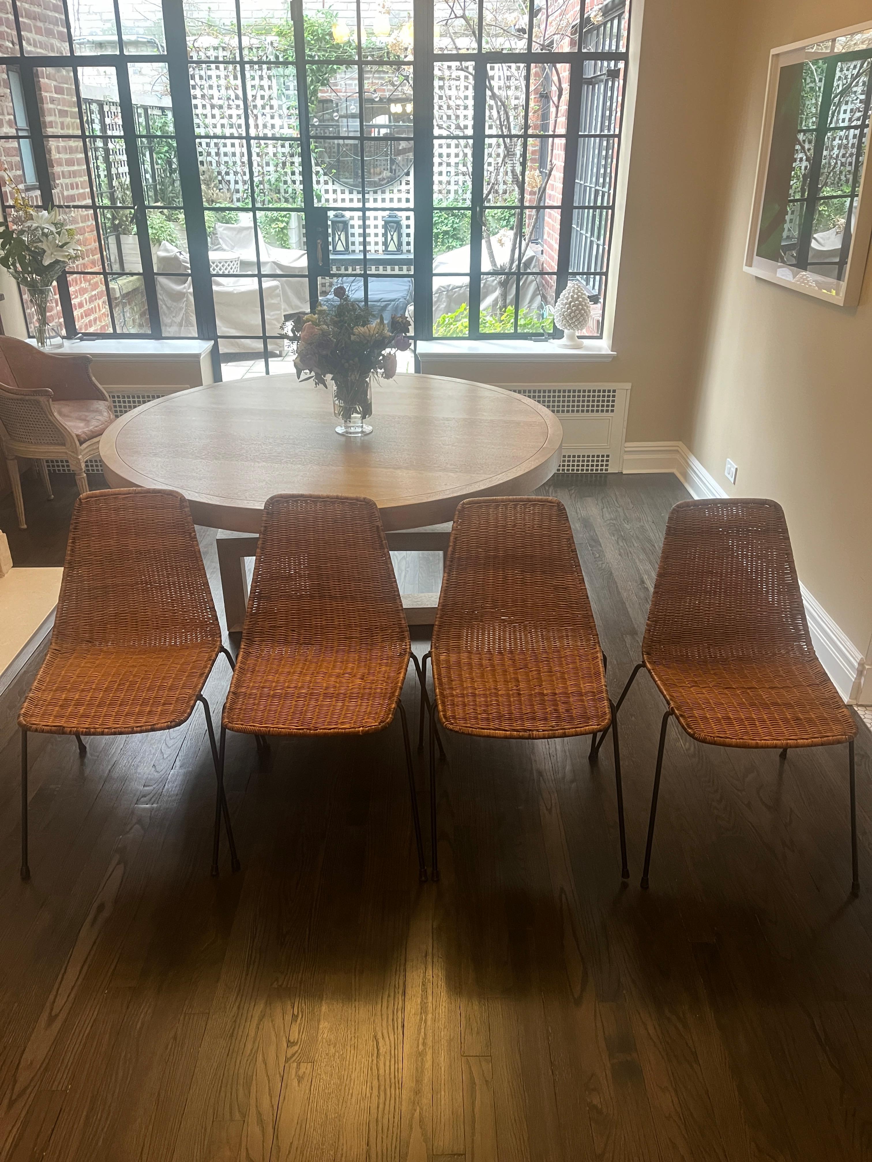Set of four (4) midcentury Italian wicker and iron dining chairs by Gian Franco Legler, 1960s. Minimalist silhouette, full wicker seat and back on thin iron splayed legs. 