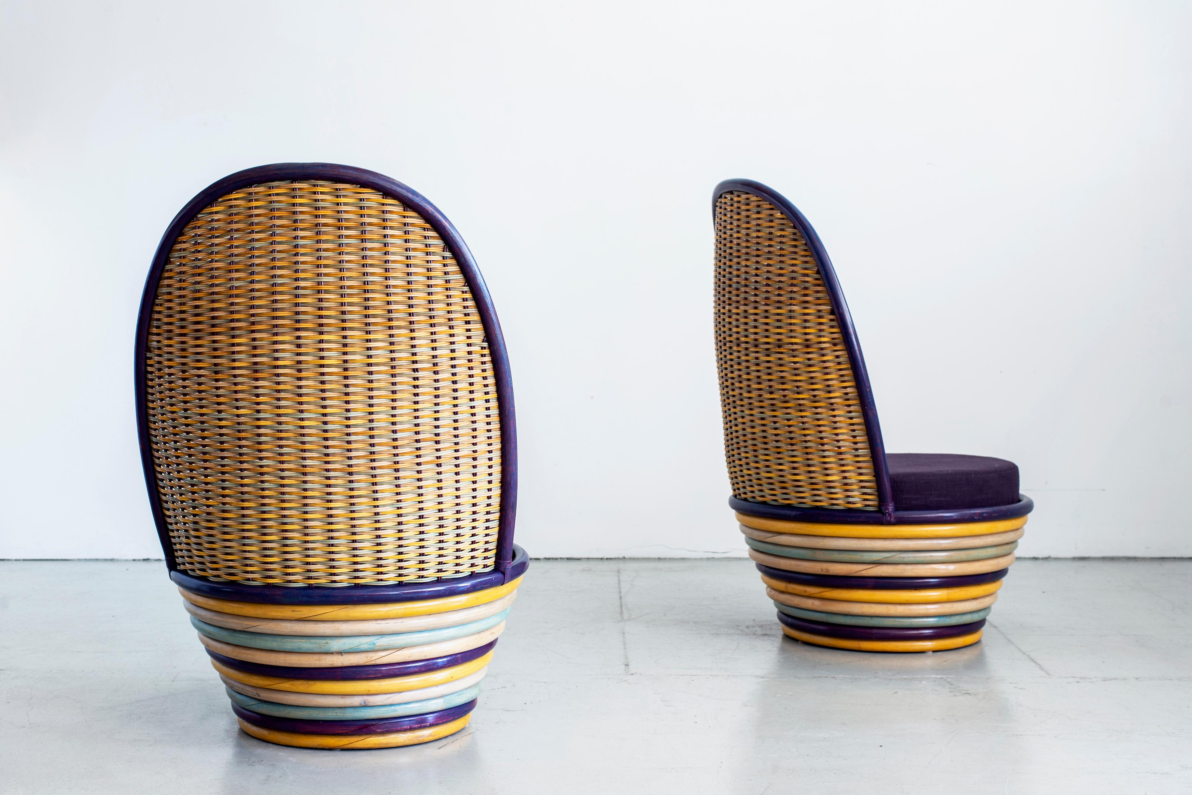 Vibrant pair of Italian woven wicker and rattan lounge chairs. Great colored striped rattan circular base and colored wicker back with newly upholstered purple cushioned seats.