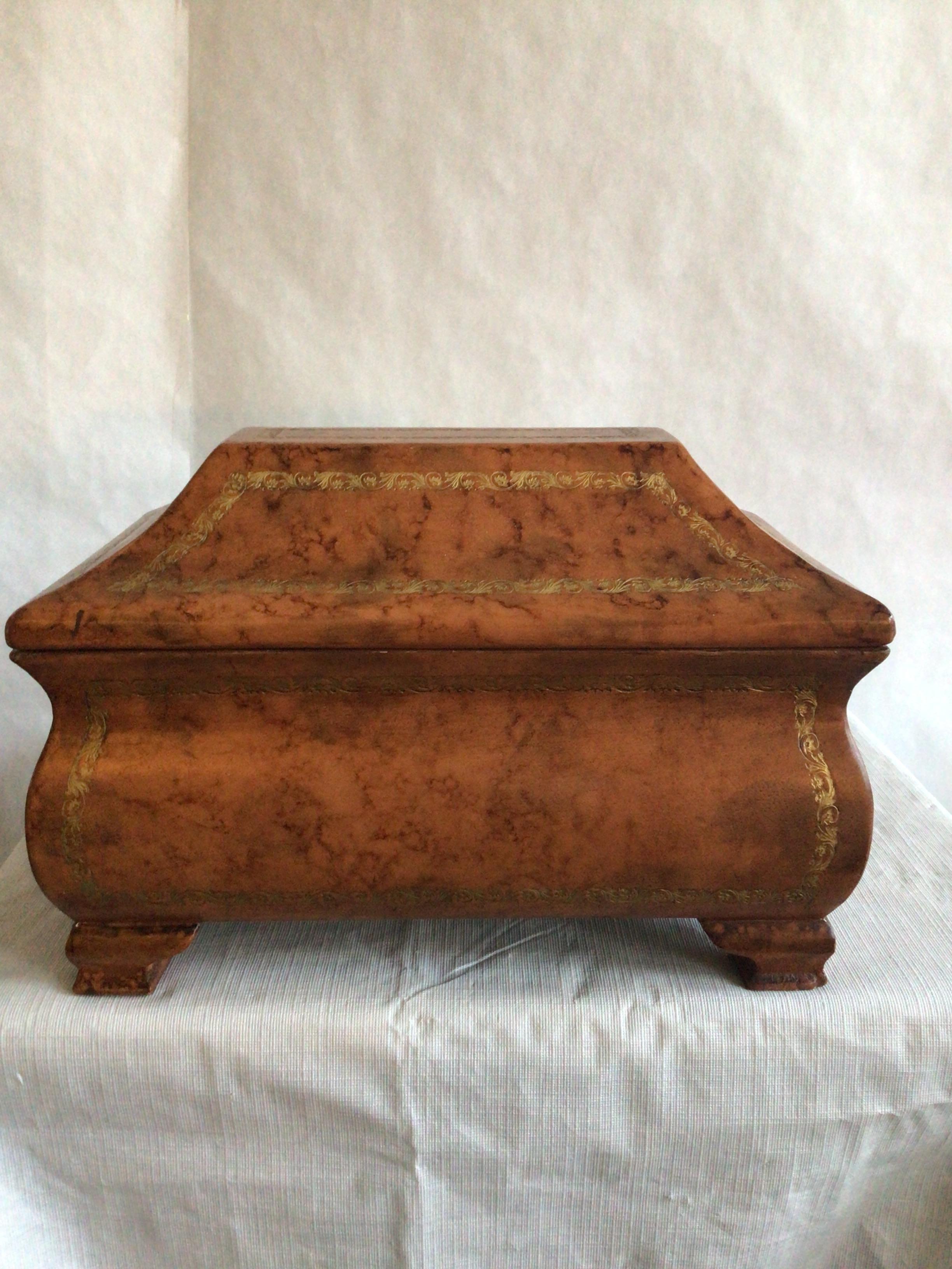 Caja de madera italiana de los años 60 forrada de cuero con detalles de pan de oro labrado
Los diseños de los bordes labrados acentúan las distintas formas de esta exquisita caja
Pies de madera recubiertos también de cuero
Tapa abatible
Interior