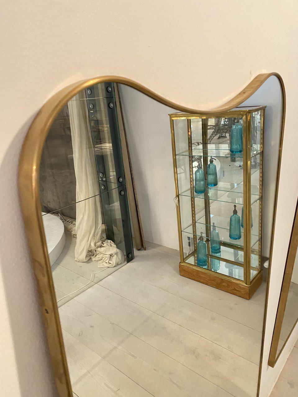 Stunning full length midcentury brass mirror from circa 1960s Italy. It has a sleek and tight quality brass frame with a rounded profile, and bowed top in its rectangular form.

Original mirrored glass, and stylistically related to the designer