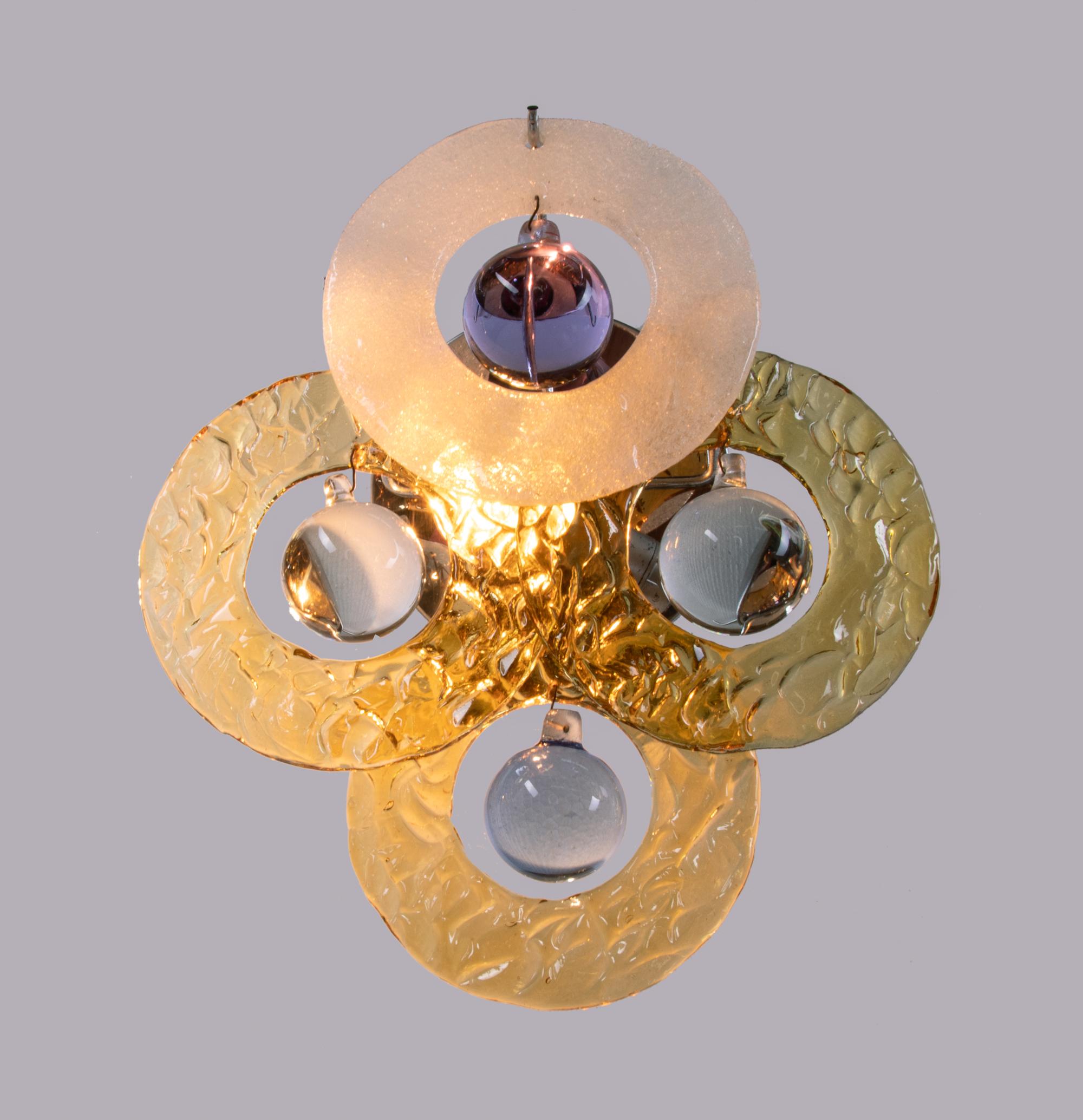 Elegantes apliques de pared con discos de cristal de Murano helado que incluyen bolas de cristal de Murano sobre un marco cromado diseñado por Gino Vistosi. Gema de la época. Con esta luz hará una clara declaración en su diseño interior. Un