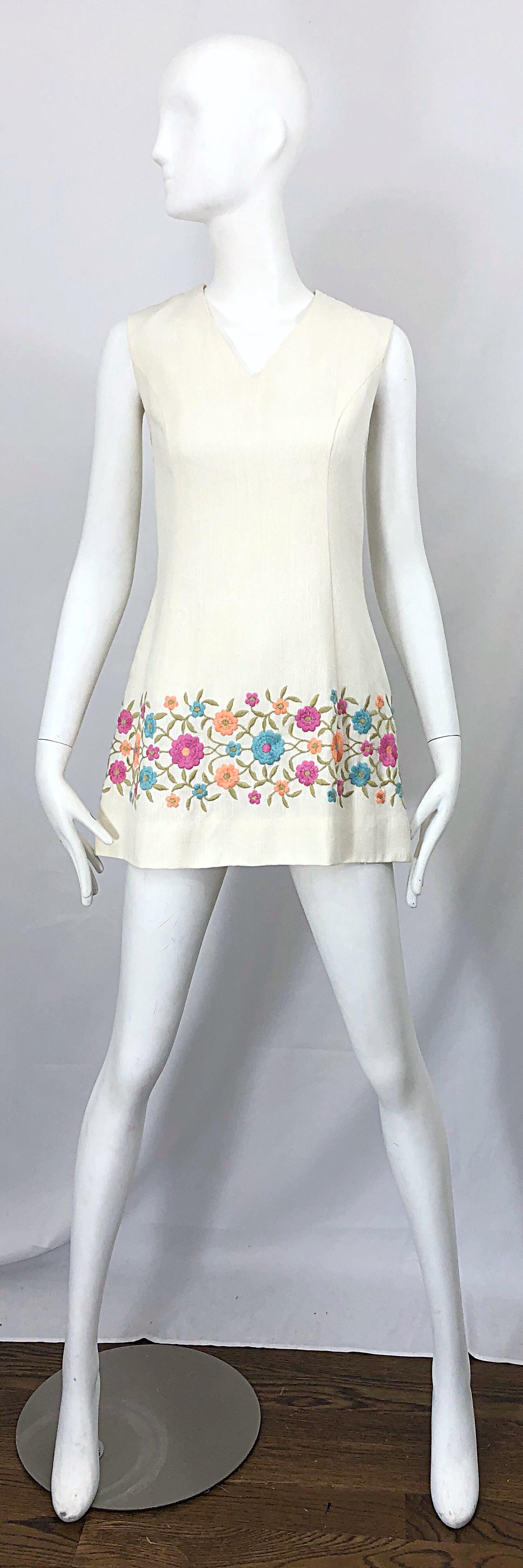 Chic Late 60s Irish Linen A-Line embroidered mini dress / tunic ! Features an ivory / off-white color with pastel pink, blue, and coral flowers embroidered at the hem. V-neck collar fitted bodice with a forgiving flare skirt. Hidden zipper up the