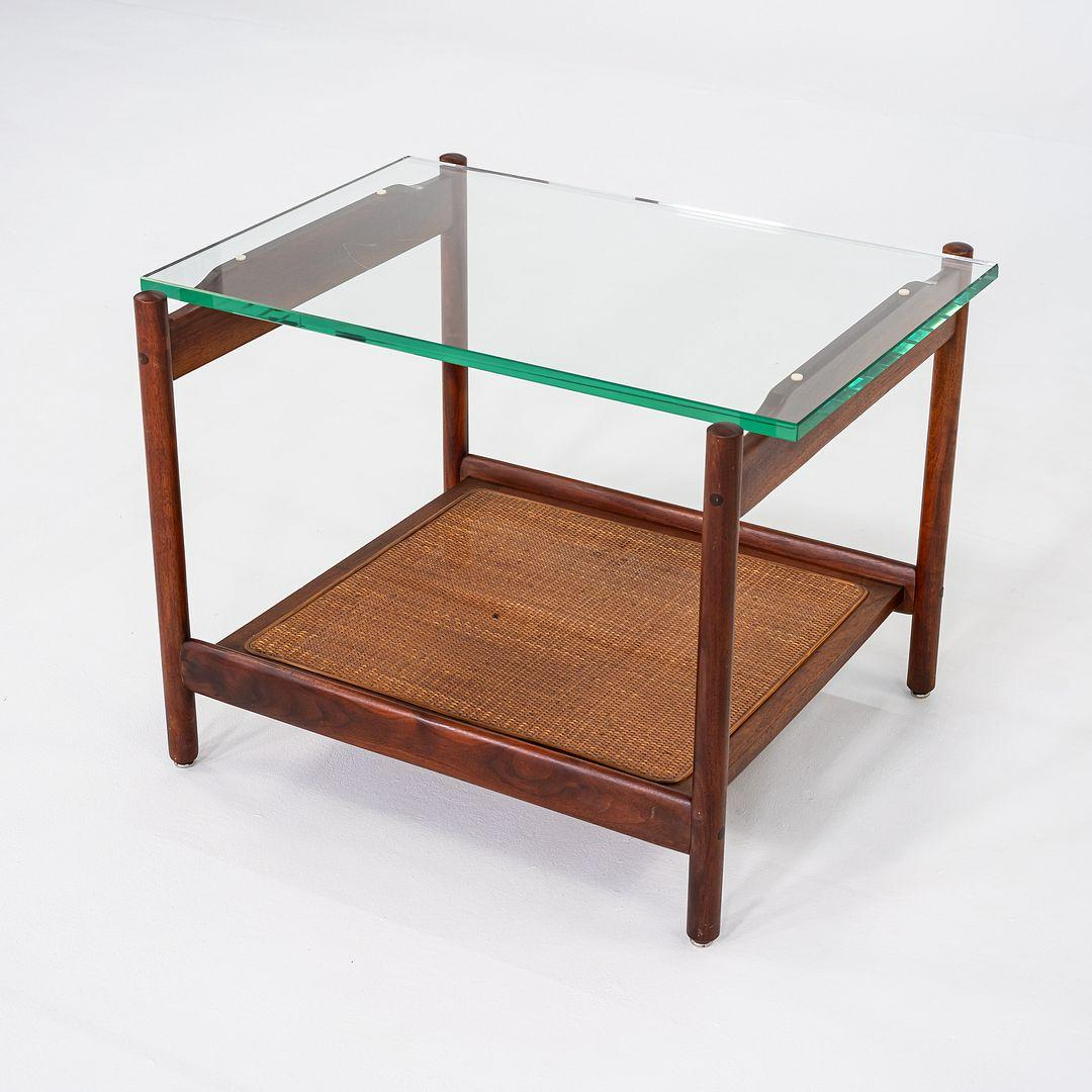 Il s'agit d'une table d'appoint ou de chevet en noyer, canne et verre, attribuée à Jack Cartwright pour Founders Furniture. Cette pièce a été produite aux États-Unis dans les années 1960. La base de la table a une forme résolument du milieu du