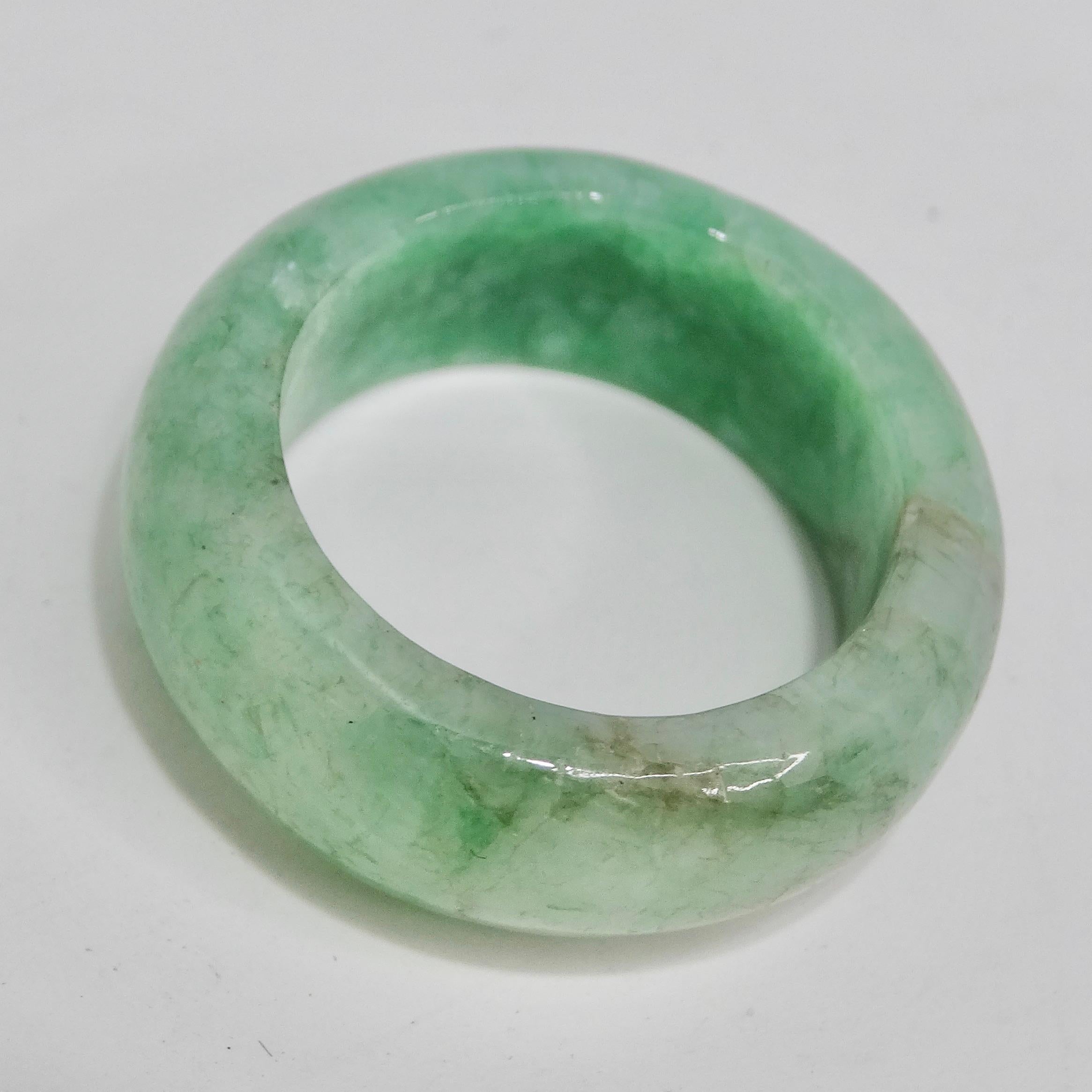 Discover the timeless beauty of our 1960s Jade Ring, a classic band ring showcasing the natural elegance of vibrant green jade. This exquisite piece, dating back to the 1960s, exudes a sense of grace and sophistication that transcends generations.