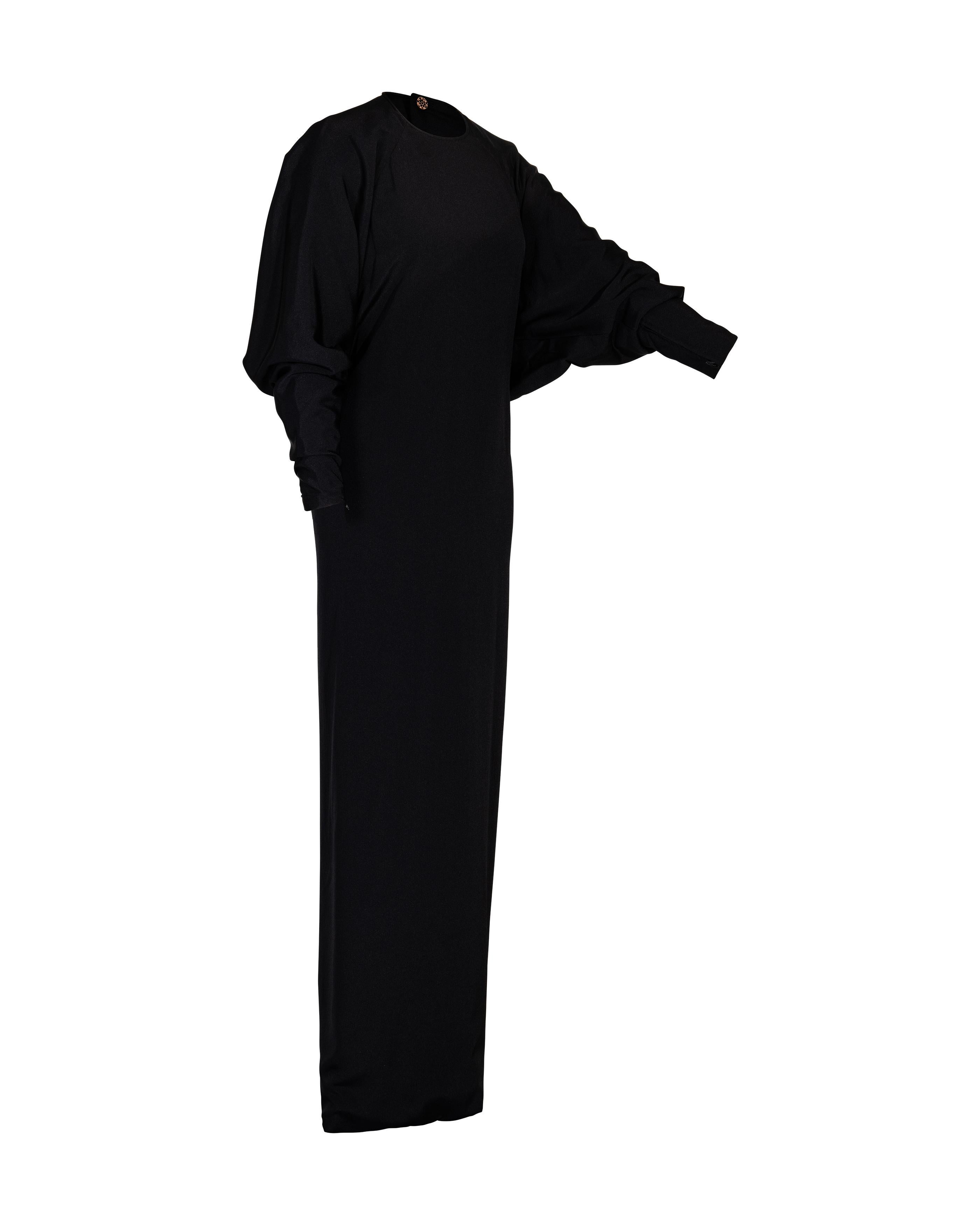 1960’s James Galanos batwing black gown with gold button-up back and hidden back zip closure. High-neck gown with fitted waist and subtle bat-wing open sleeves. A timeless piece. 