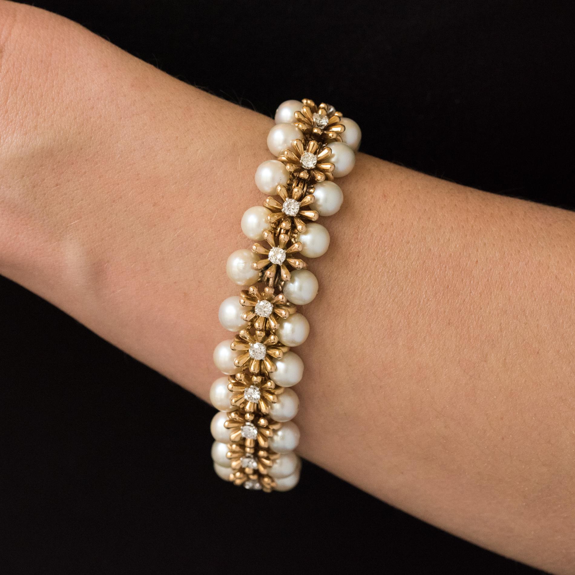 Bracelet in 18 karats yellow gold, owl hallmark.
This splendid jewelry bracelet consists of a line of 21 flowers with drops of petals, whose hearts are brilliant- cut diamonds. It is bordered on both sides by 42 Akoya Japanese cultured pearls